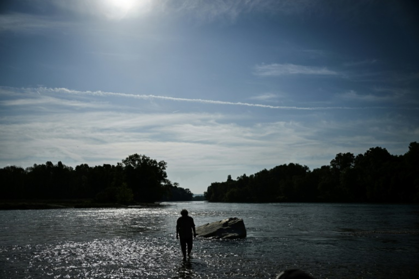 Un homme marche dans le Rhône à Saint-Romain-de-Jalionas, en Isère, le 10 octobre 2023 © OLIVIER CHASSIGNOLE