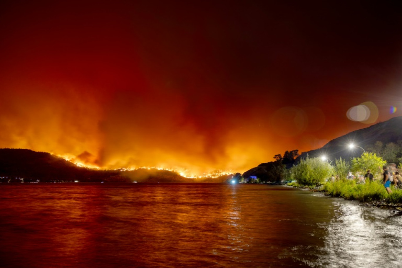 Des résidents observent le feu de forêt de McDougall Creek à West Kelowna, en Colombie-Britannique, au Canada, le 17 août 2023. © Darren HULL