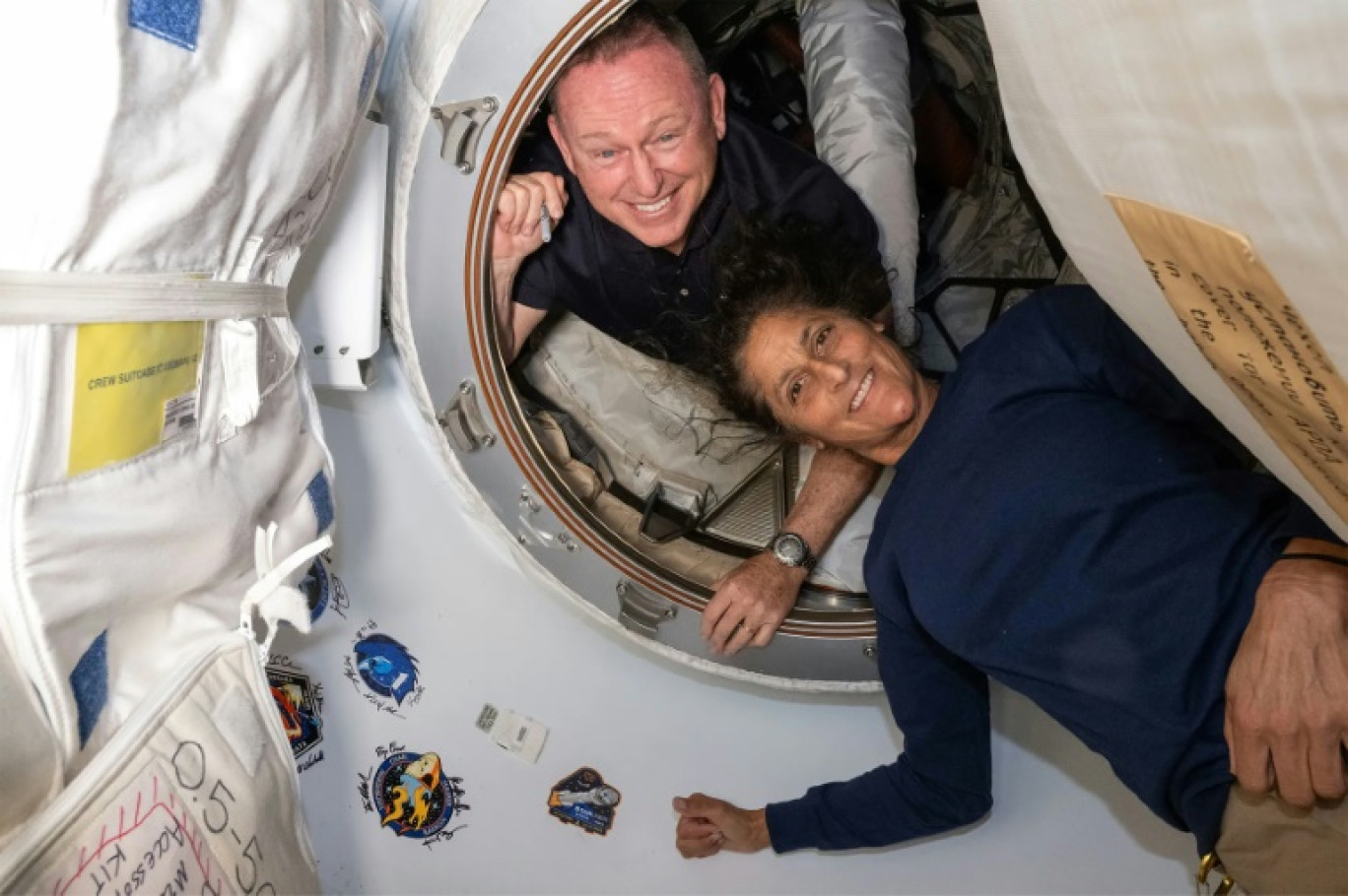 Photo non datée de la Nasa diffusée le 2 juillet 2024 des astronautes Butch Wilmore et Suni Williams (d) à l'intérieur du vestibule entre le port avant du module Harmony de la Station spatiale internationale (ISS) et le vaisseau spatial Starliner de Boeing © Handout