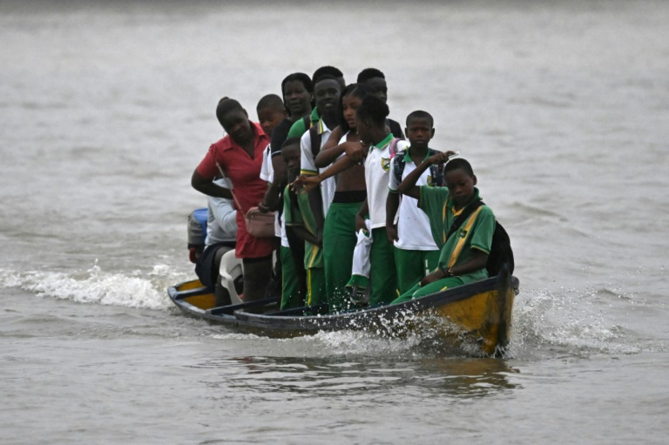 Des étudiants traversent le fleuve Atrato dans un bateau à moteur en bois pour aller étudier dans la municipalité de Quibdo, département de Choco, Colombie, le 30 août 2024 © Raul ARBOLEDA