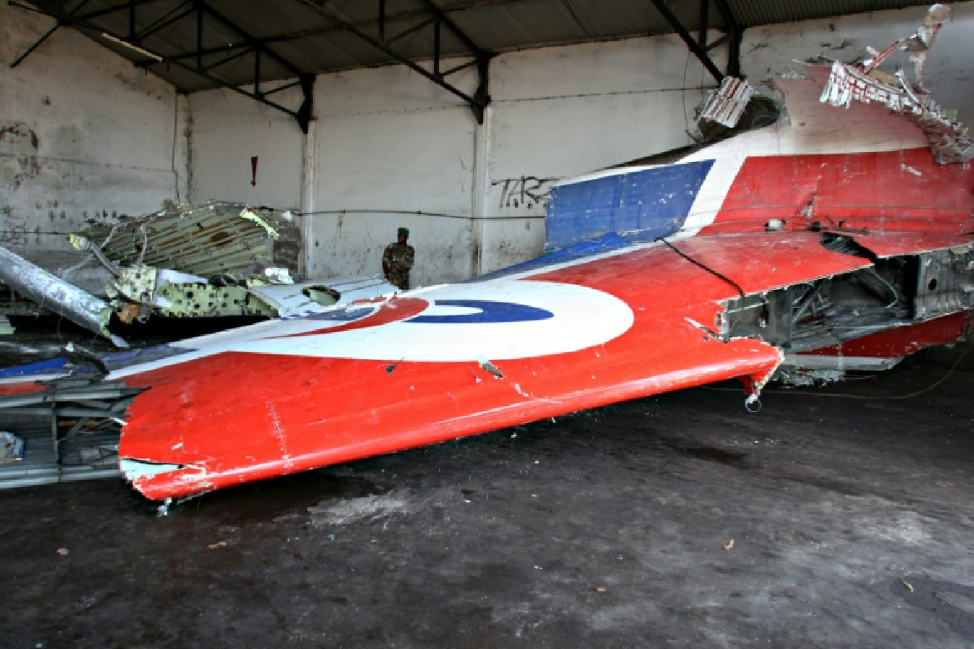 Un soldat comorien regarde des restes de l'avion de la Yemenia Airways récupérés dans l'océan Indien dans un hangar désaffecté de l'aéroport de Moroni le 16 septembre 2009, aux Comores © YUSUF IBRAHIM