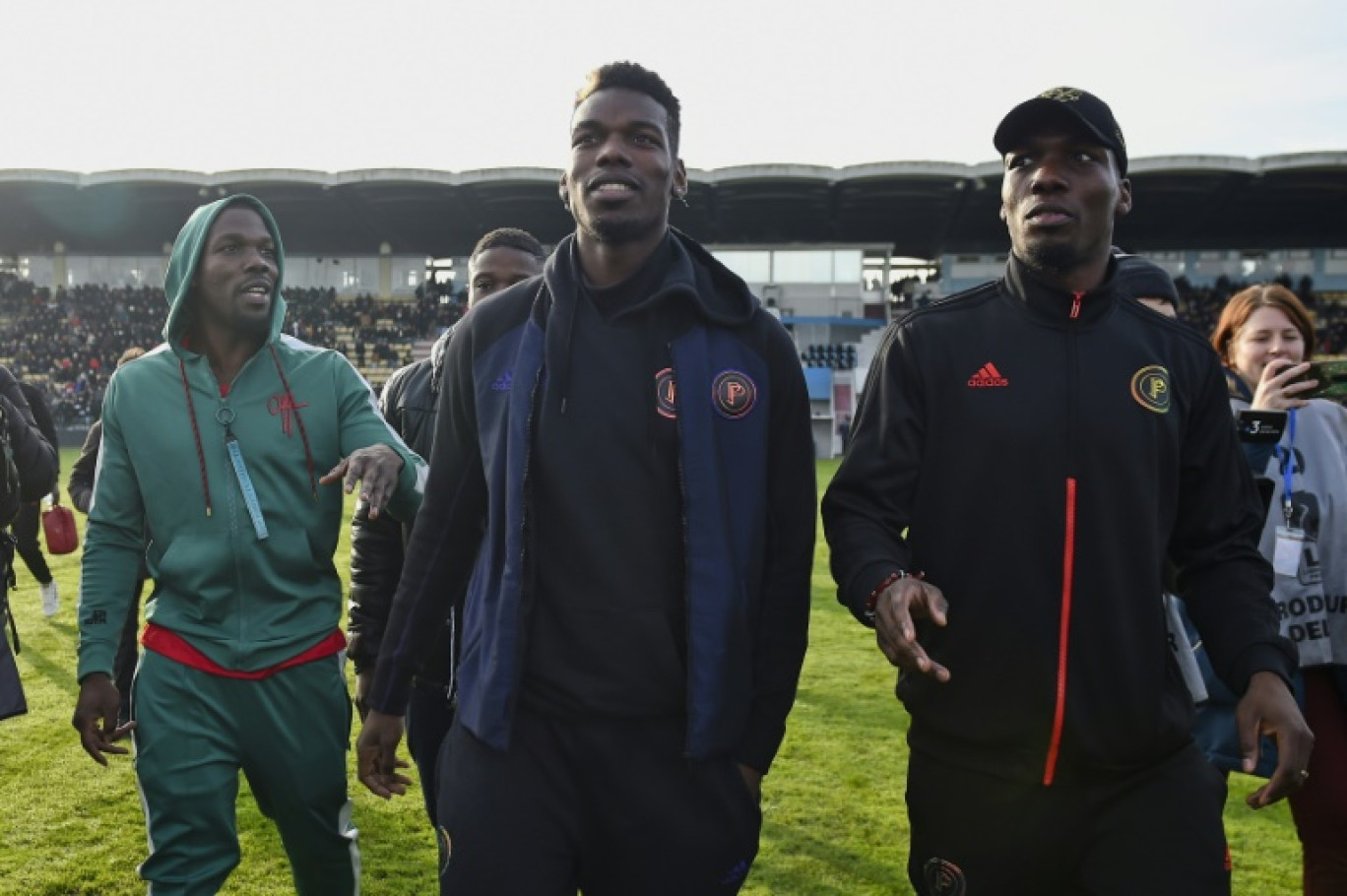 Le joueur de football Paul Pogba, entouré de ses frères Mathias (droite) et Florentin gauche), le 29 décembre 2019 au stade de Tours © GUILLAUME SOUVANT