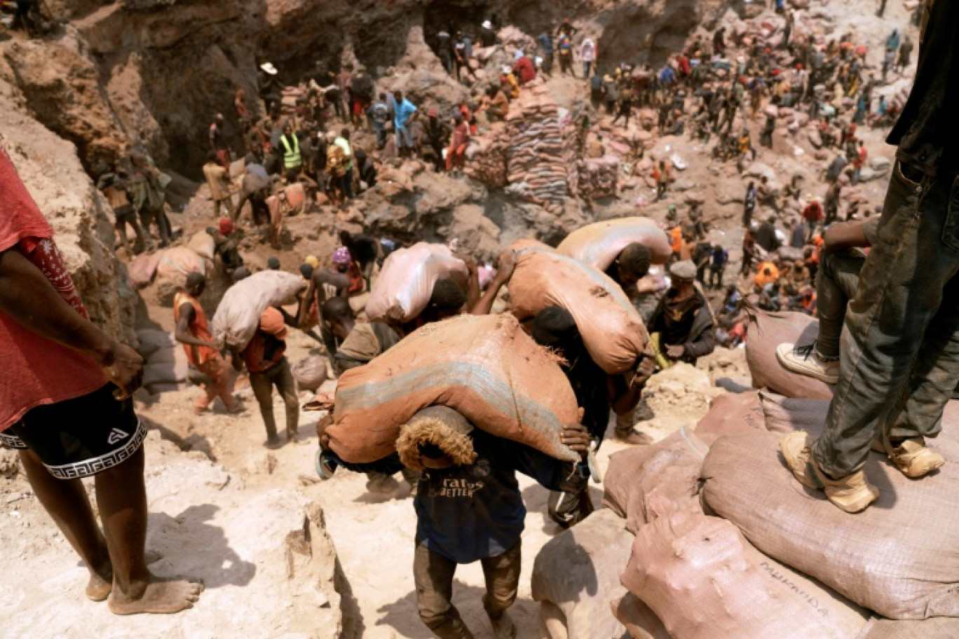 Des mineurs artisanaux transportent des sacs de minerai à la mine artisanale de Shabara, près de Kolwezi, en République démocratique du Congo, le 12 octobre 2022 © Junior KANNAH