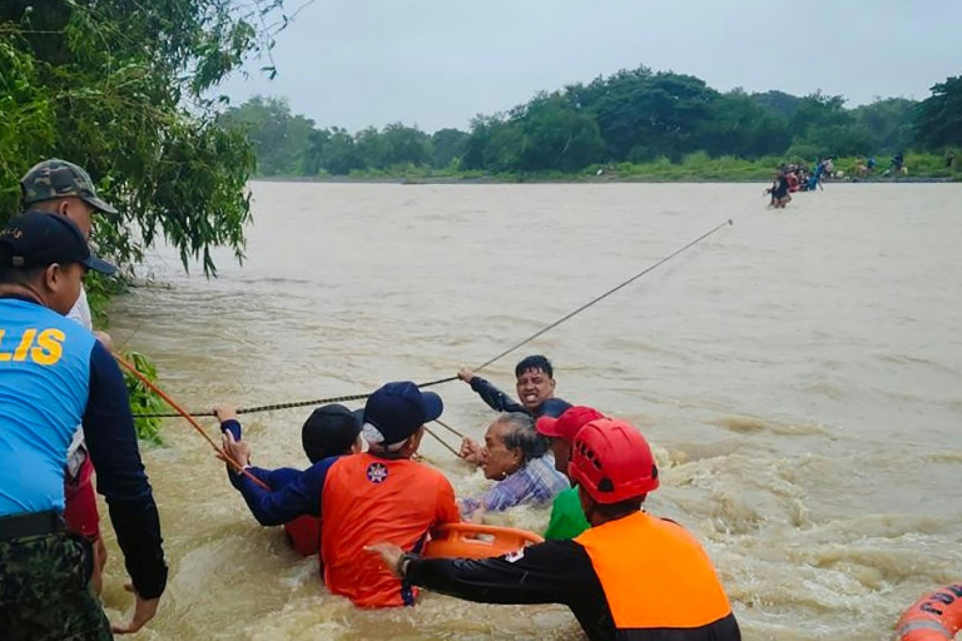 Une photo prise le 14 septembre par les garde-côtes philippins montre des secouristes évacuant les résidents alors que de fortes pluies ont déclenché des inondations provoquées par la tempête tropicale Bebinca dans la ville de Rizal, province de Mindoro occidental. © Handout