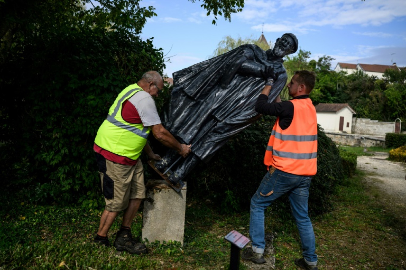 Des employés municipaux déboulonnent une statue de l'abbé Pierre, à Norges-la-Ville, le 17 septembre 2024 en Côte d'Or © JEFF PACHOUD