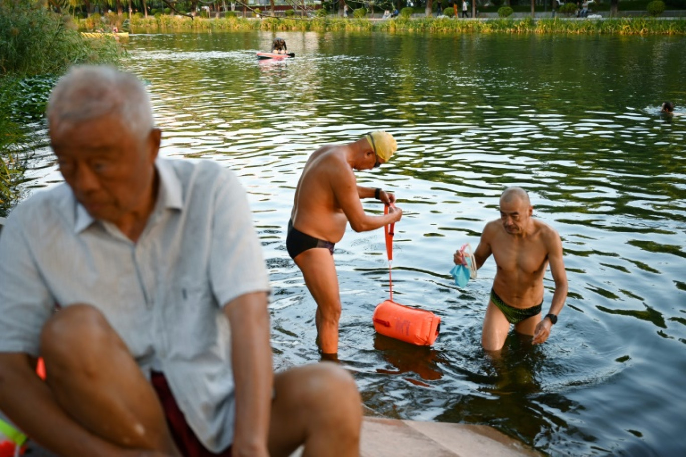 Des hommes âgés nagent dans la rivière Liangma durant les vacances de la Fête de la mi-automne, à Pékin, le 16 septembre 2024. © GREG BAKER