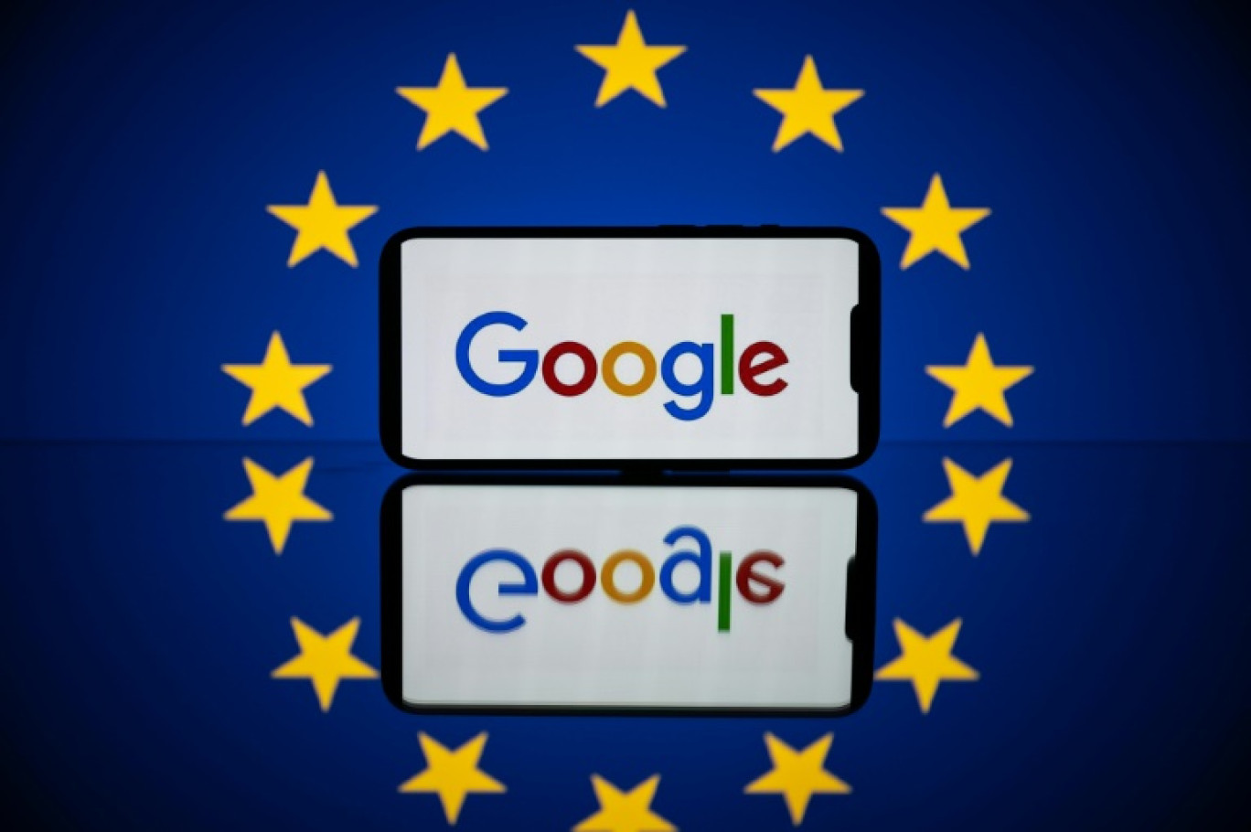 Le logo de Google sur un téléphone devant un drapeau européen. Photo prise le 27 avril 2023 à Toulouse © Lionel BONAVENTURE