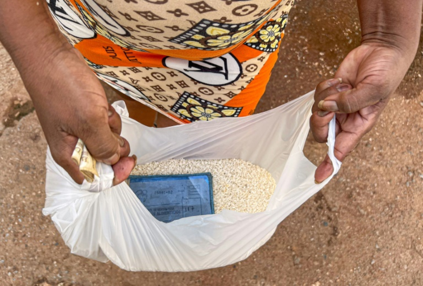 Une Cubaine montre la ration mensuelle de riz attribuée à sa famille comme part des aliments prévus dans le carnet de rationnement, le 17 septembre à La Havane © ADALBERTO ROQUE