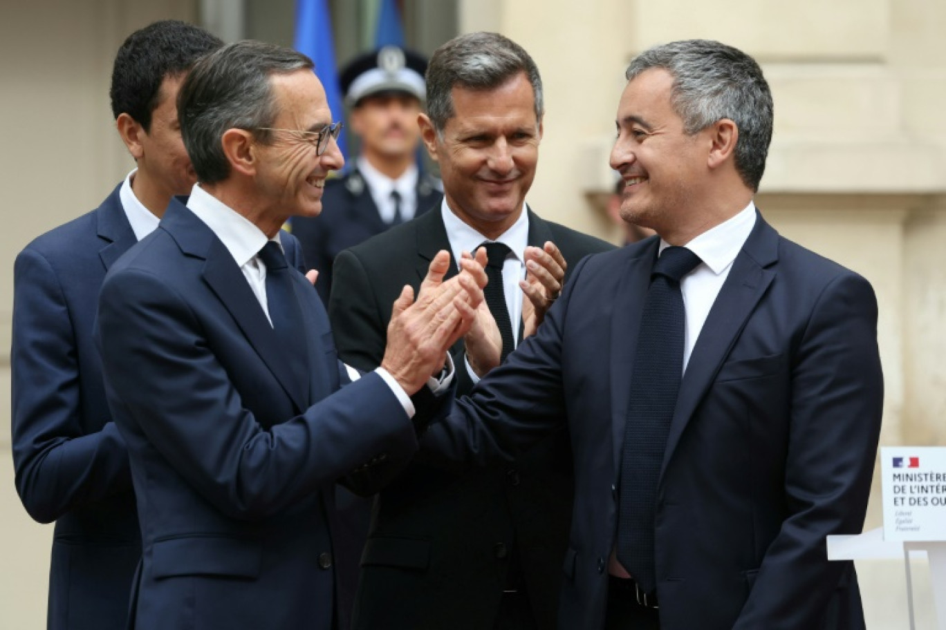 Le nouveau ministre de l'Intérieur Bruno Retailleau (g) applaudit Gérald Darmanin lors de la passation de pouvoir à l'hôtel de Beauvau le 23 septembre 2024 à Paris © Alain JOCARD