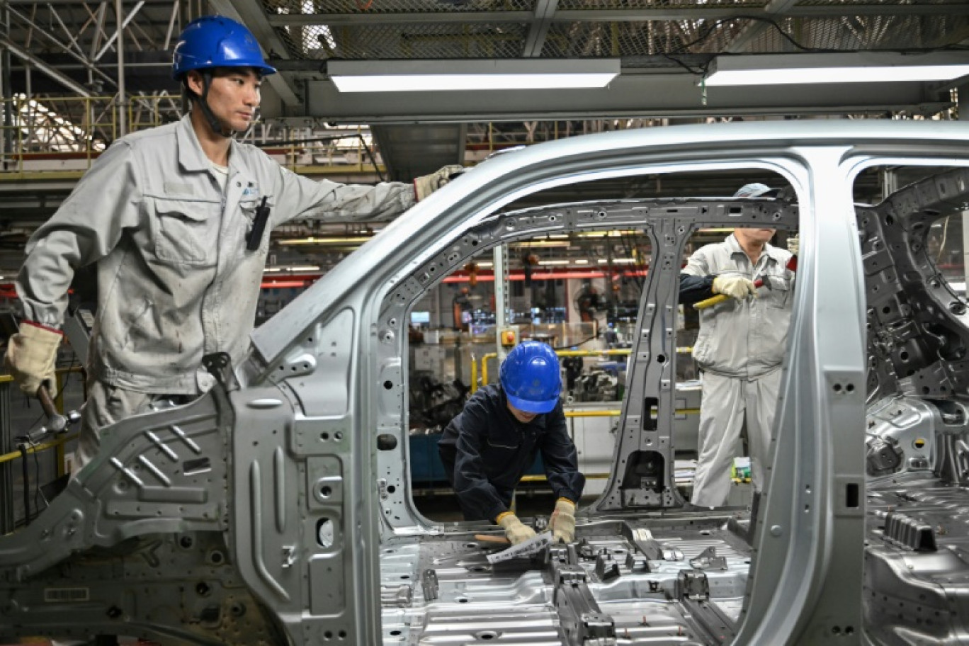 Des employés travaillent sur une ligne de production de véhicules électriques à l'usine Leapmotor de Jinhua, en Chine, le 18 septembre 2024 © ADEK BERRY