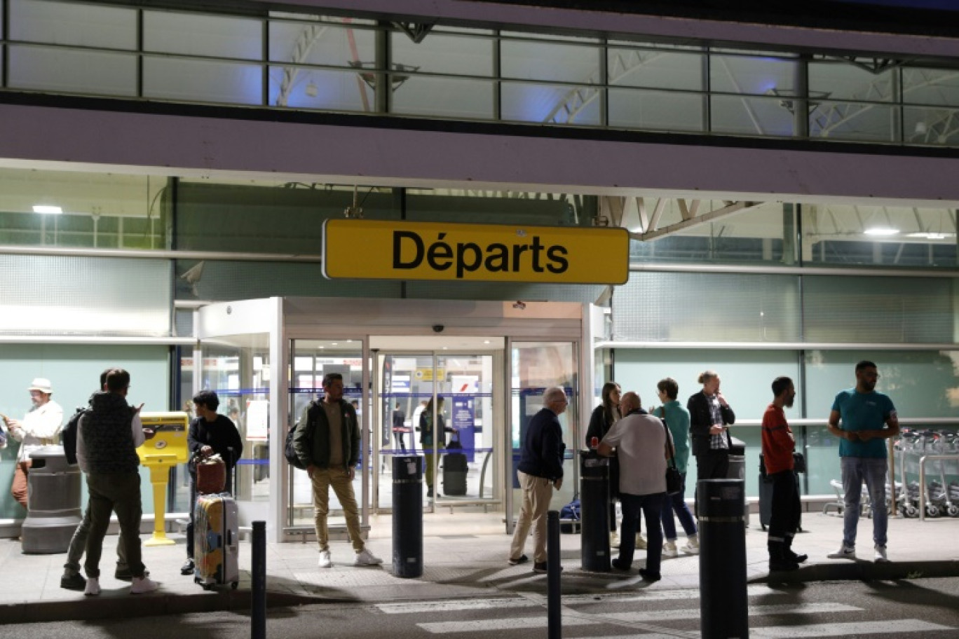 Des passagers attendent devant l'aéroport Napoléon Bonaparte d'Ajaccio, en Corse, le 3 octobre 2024 © Pascal POCHARD-CASABIANCA