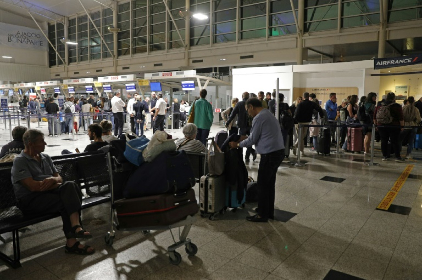 Des passagers attendent devant l'aéroport Napoléon Bonaparte d'Ajaccio, en Corse, le 3 octobre 2024 © Pascal POCHARD-CASABIANCA