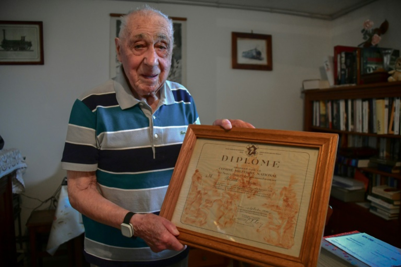 L'ancien résistant français Edmond Réveil pose avec son diplôme de franc-tireur à Meymac, le 20 juin 2023 © PASCAL LACHENAUD