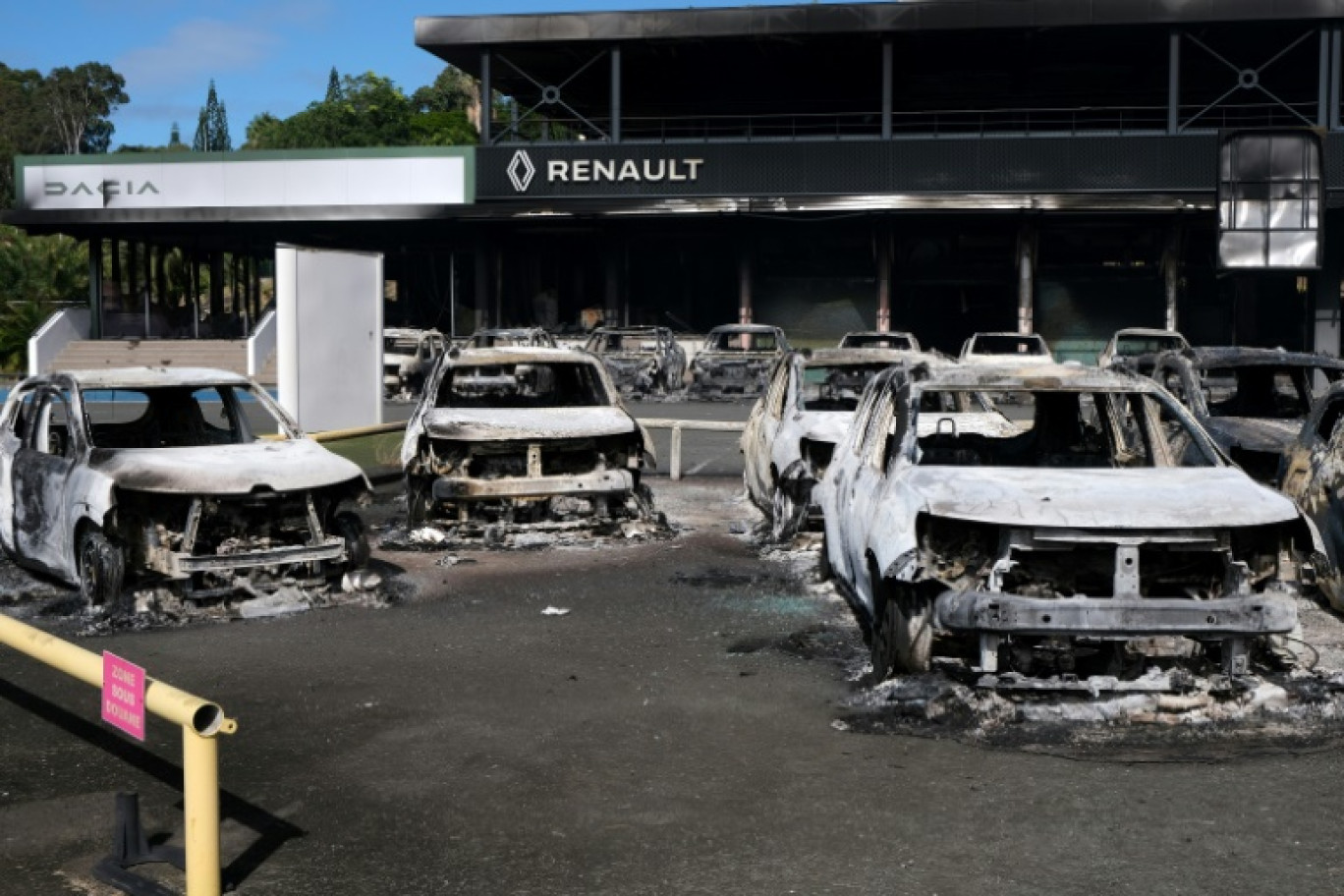 Des voitures incendiées devant un concessionnaire automobile du quartier Magenta à Nouméa, le 14 mai 2024 © Theo Rouby