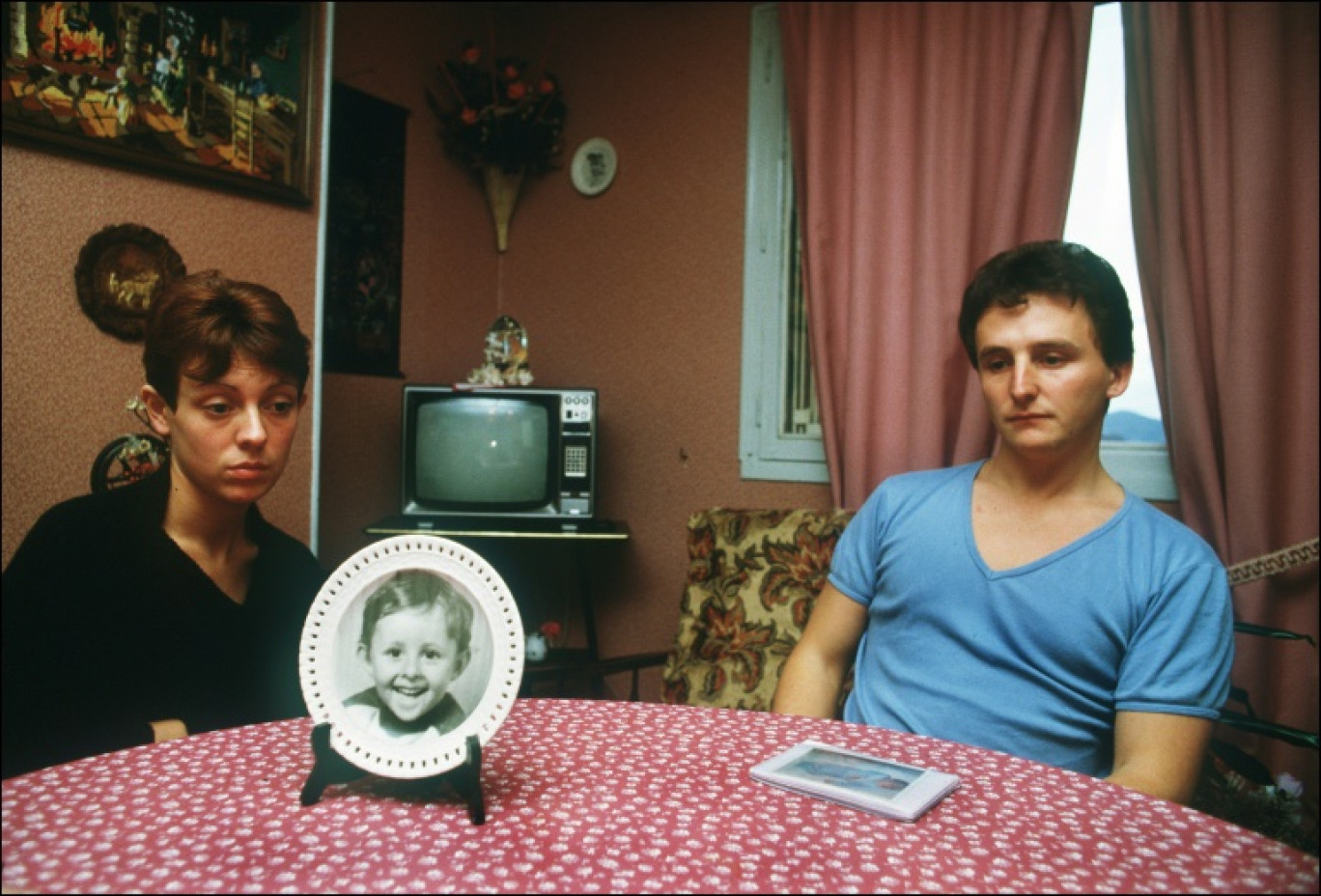 Christine et Jean-Marie Villemin sont photographiés chez eux, avec un portrait de leur fils Grégory, le 23 novembre 1984 à Lépanges-sur-Vologne, dans les Vosges © ERIC FEFERBERG