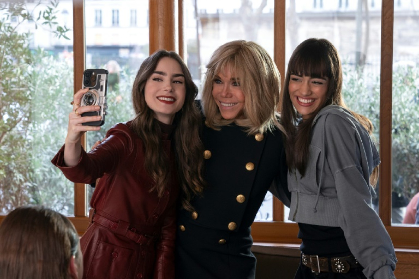 De gauche à droite : Lily Collins, la star de "Emily in Paris", l'épouse du président de la République Brigitte Macron et l'actrice Thalia Besson lors du tournage de la série Netflix à Paris, le 2 avril 2024 © Handout