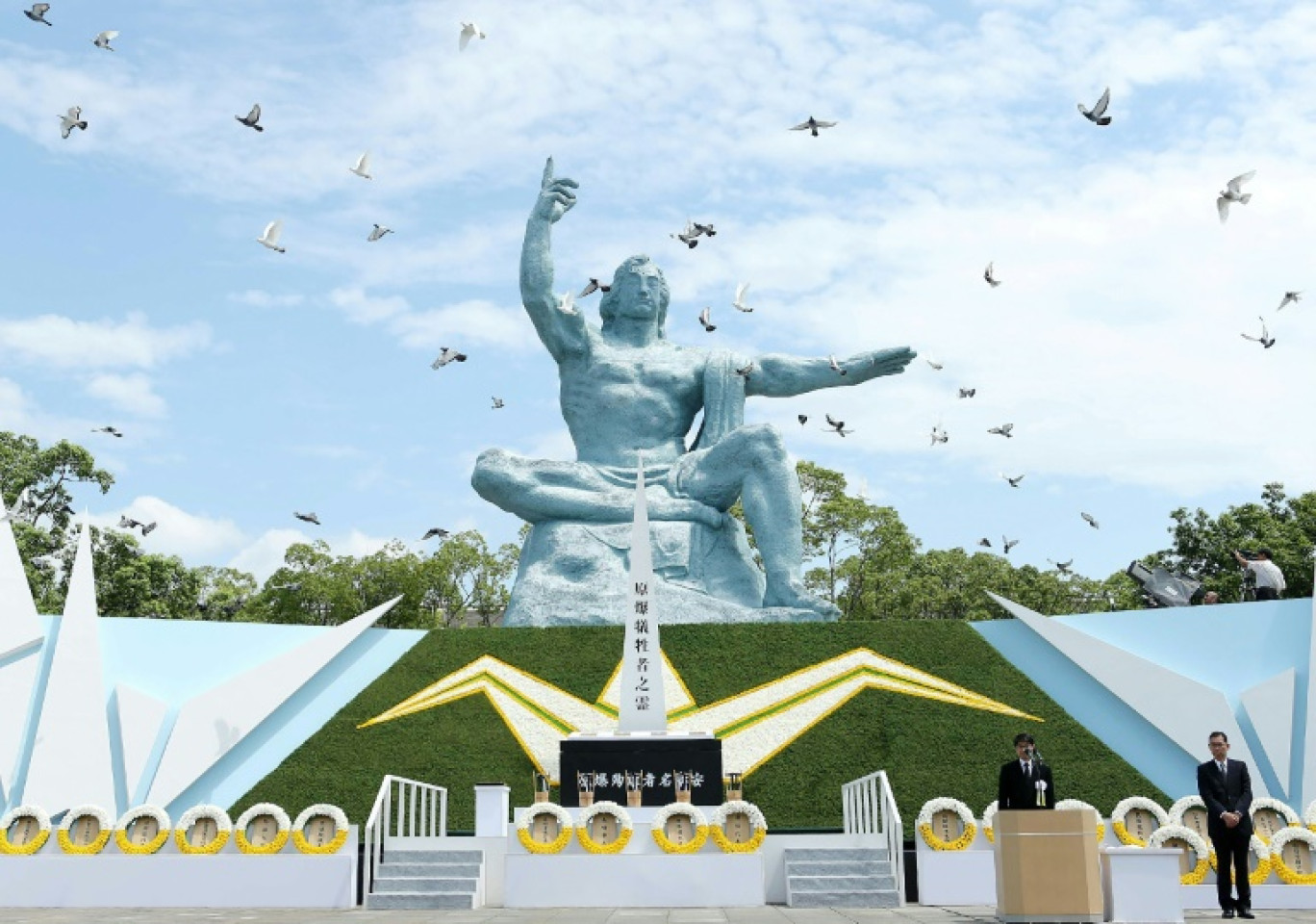 Des colombes volent autour du monument du Parc commémoratif de la paix à Nagasaki, lors d'une cérémonie marquant l'anniversaire du bombardement atomique, le 9 août 2016 au Japon © JIJI PRESS