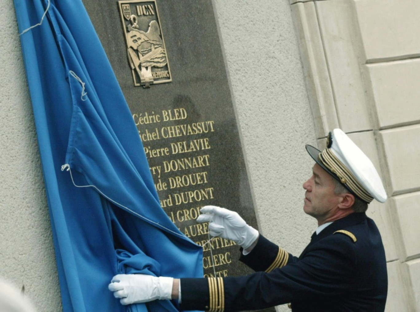 Le préfet de la Manche dévoile, le 8 mai 2003 à l'entrée de l'arsenal de Cherbourg, une plaque à la mémoire des onze techniciens de la DCN victimes de l'attentat de Karachi, il y a un an © BERTRAND LEBAS