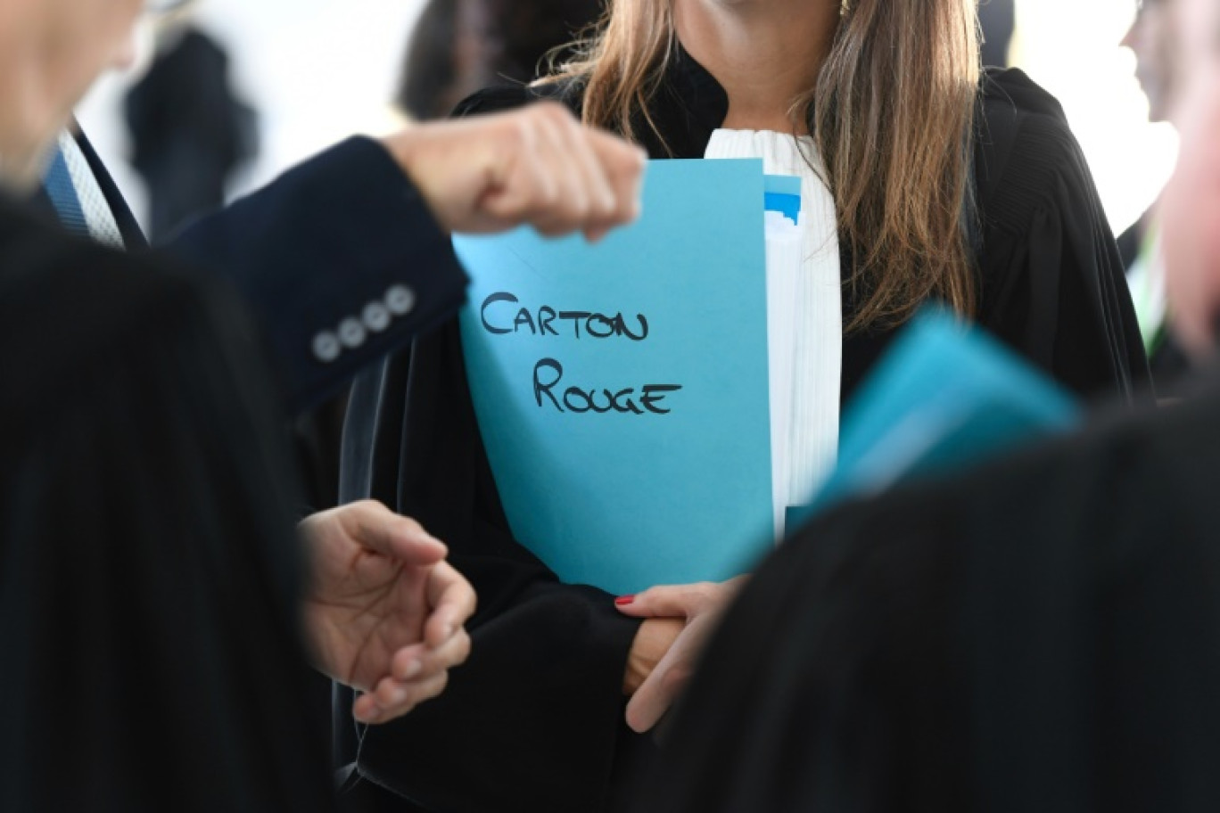 Un avocat tient un dossier portant l'inscription "Carton rouge" à l'ouverture du procès au centre des congrès à Nancy, le 21 octobre 2024 © Jean-Christophe VERHAEGEN