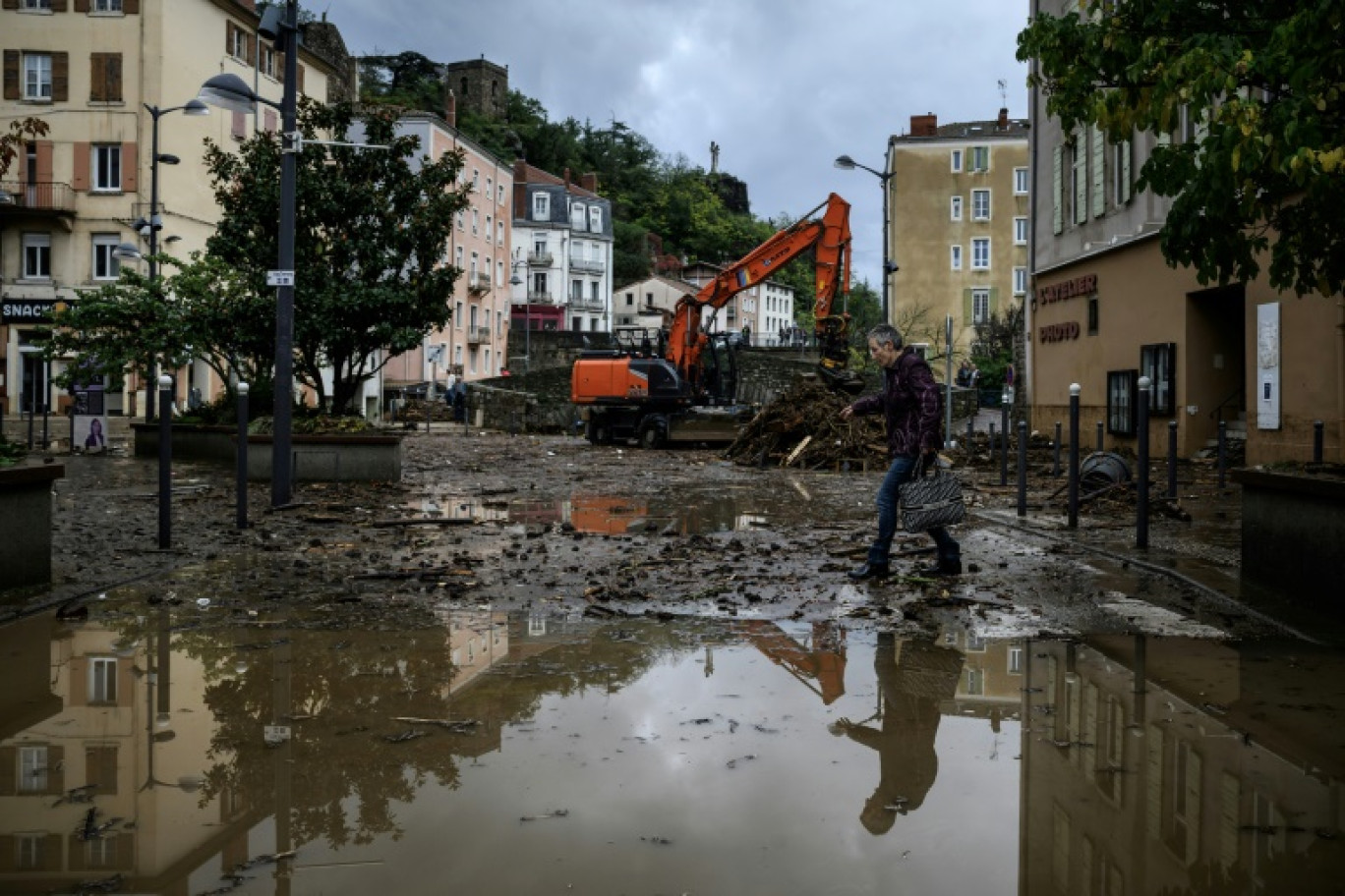 Un habitant dégage la boue d'un magasin au lendemain des inondations, le 18 octobre 2024 à Annonay, en Ardèche © JEFF PACHOUD