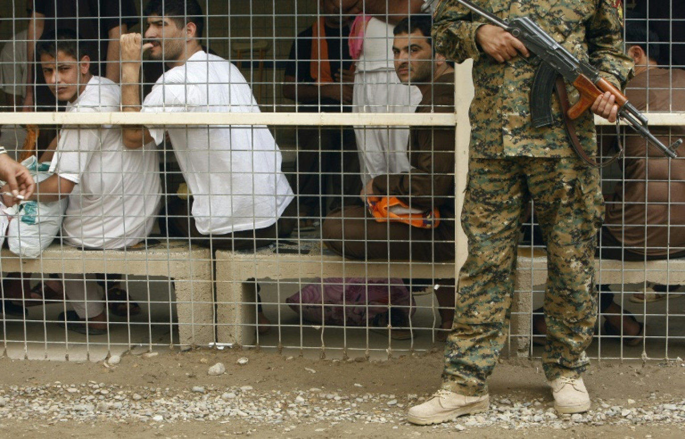 Un soldat irakien monte la garde devant des détenus attendant d'être relâchés, le 29 avril 2010 à la prison d'Al-Rusafa, à Bagdad © SABAH ARAR