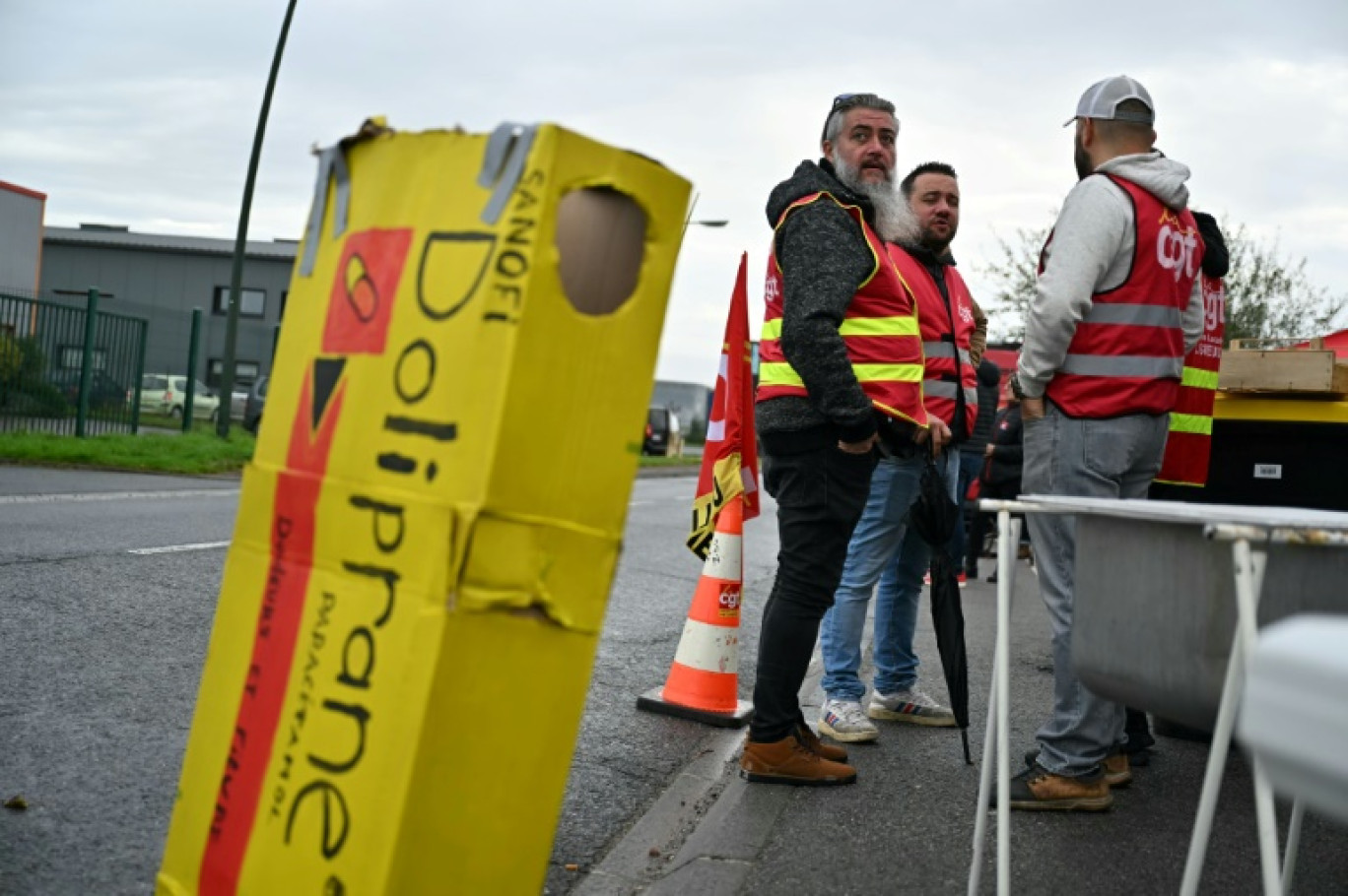 Des employés et des syndicalistes en grève devant leur usine qui fabrique le Doliprane à Lisieux (nord-ouest de la France), après l'annonce par Sanofi de négociation en cours avec le fonds d'investissement américain CD&R afin de lui céder potentiellement 50% de la  d'Opella, sa filiale qui commercialise notamment ce paracétamol en France. Photo prise le 17 octobre © LOU BENOIST