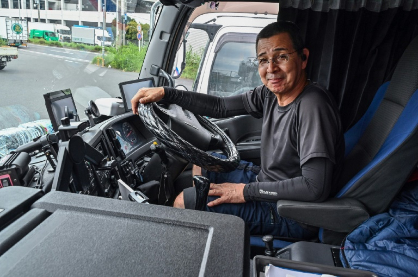 Le chauffeur routier Fujio Uemura au volant de son camion dans une zone industrielle de Kawasaki, le 4 septembre 2024 au Japon © Richard A. Brooks