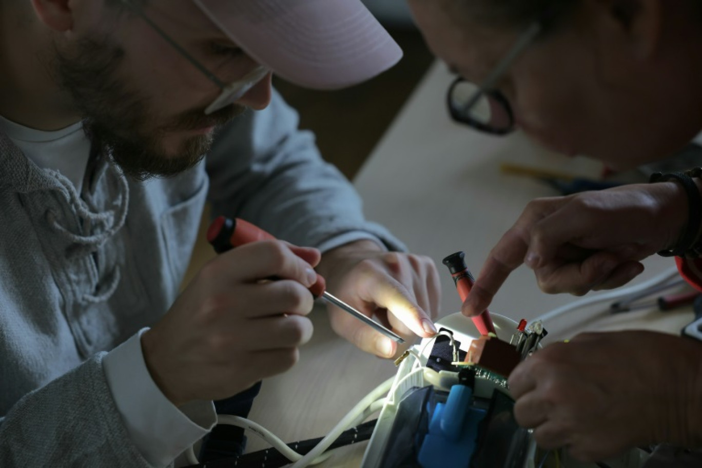 Des bénévoles réparent un appareil électrique dans un "repair café" à Paris, le 17 octobre 2024 © Thomas SAMSON