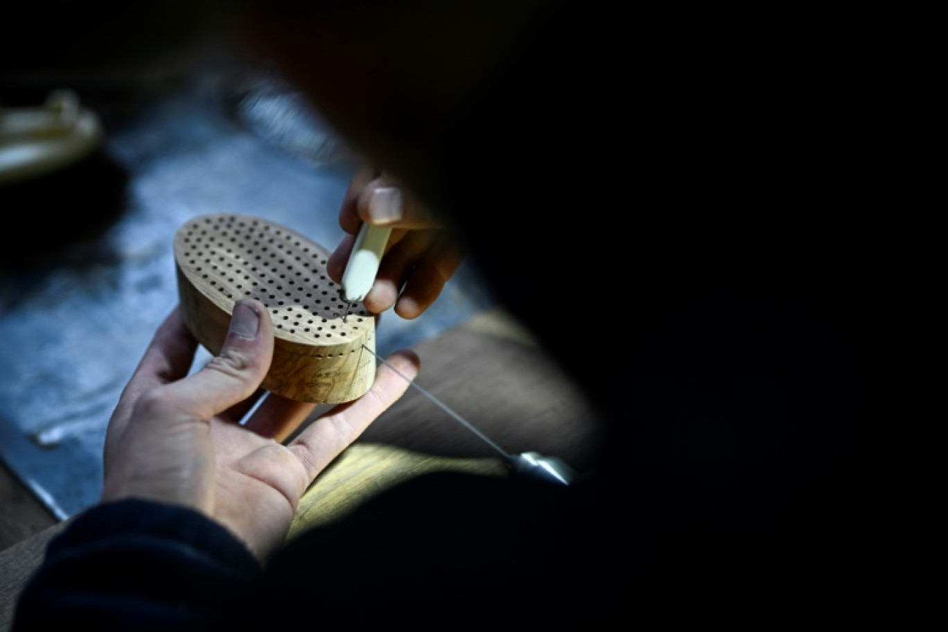 Un employé prépare un manche en bois qui servira à fabriquer une brosse à cheveux dans la fabrique de brosses Altesse à Mouy, dans l'Oise, le 9 octobre 2024 © JULIEN DE ROSA