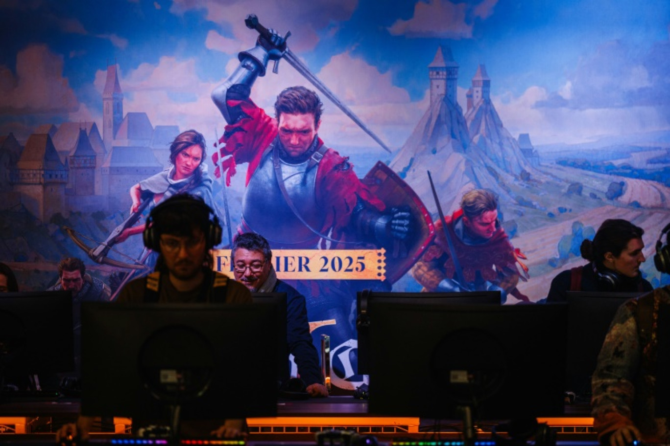 Des visiteurs jouent au jeu vidéo "Kingdom Come Deliverance II" de Warhorse Studios et édité par Deep Silver lors de la soirée de préouverture du salon "Paris Games Week" à Paris, le 22 octobre 2024 © Dimitar DILKOFF