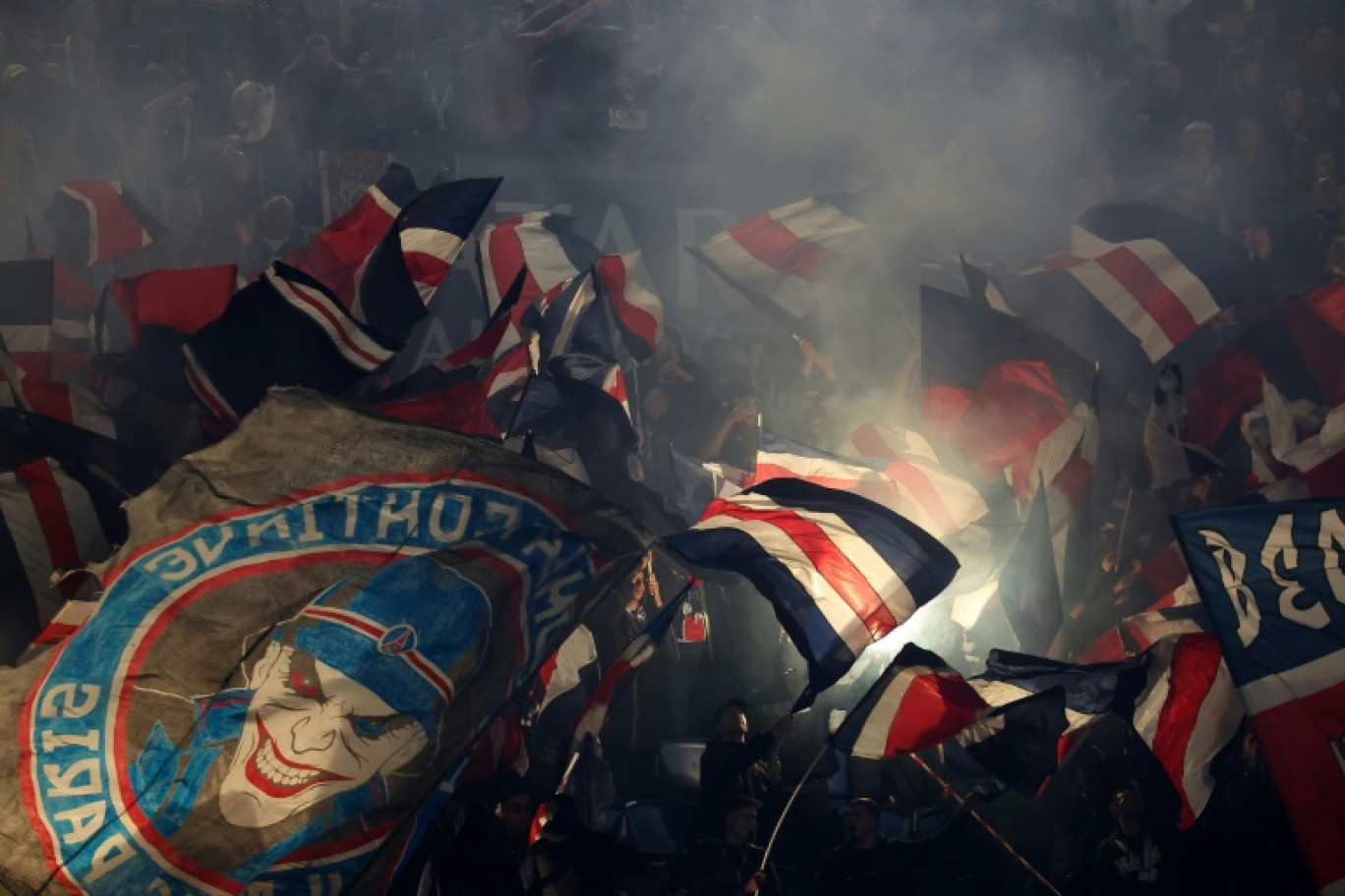 Des supporters parisiens agitent des drapeaux avant le match de football de Ligue 1 entre le Paris Saint-Germain (PSG) et le RC Strasbourg Alsace au Parc des Princes à Paris, le 19 octobre 2024 © FRANCK FIFE