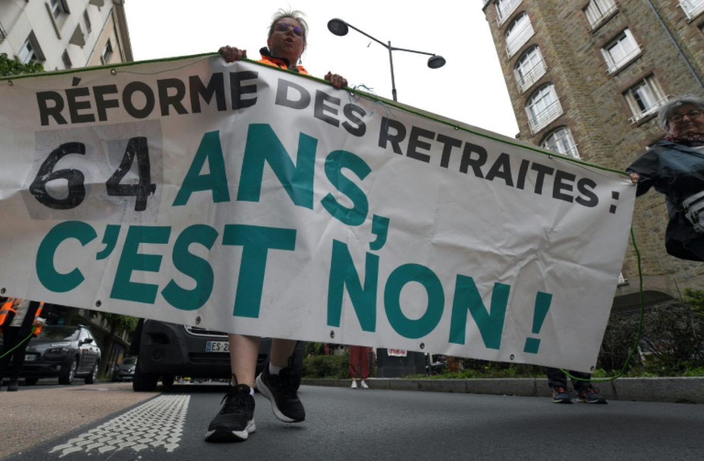 Un manifestant tient une banderole sur laquelle on peut lire "64 ans, c'est non !" lors d'une manifestation contre la réforme des retraites, à Rennes, le 23 mai 2023 © JEAN-FRANCOIS MONIER