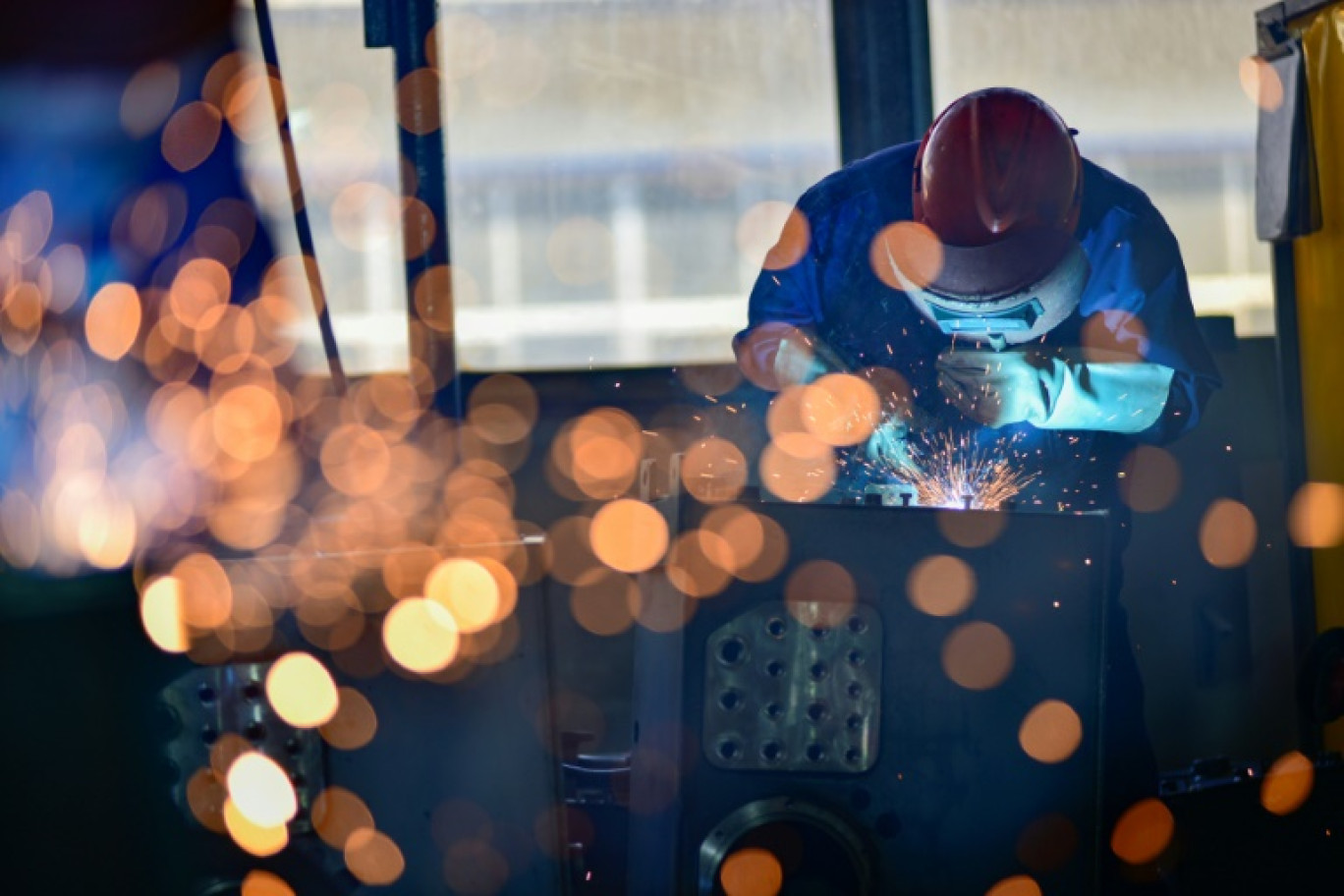 Des ouvriers soudent des pièces dans une usine qui produit des cabines de pelleteuses à Qingzhou, dans la province du Shandong (est de la Chine), le 31 octobre 2024 © STR