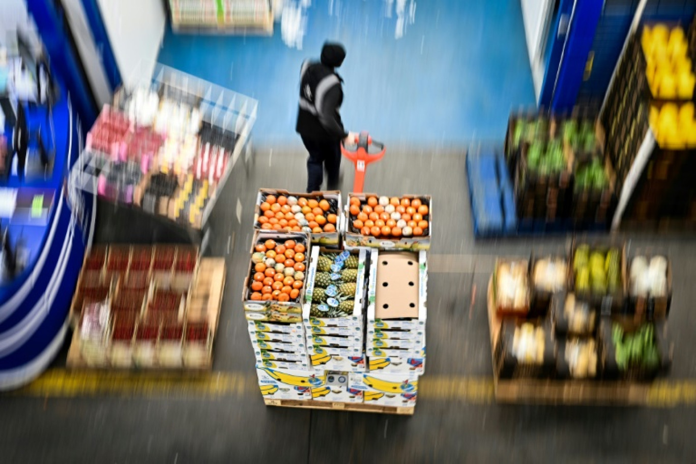 Un employé déplace des cageots au marché de fruits, légumes et fleurs de Covent Garden, à Londres, le 24 avril 2024 © Justin TALLIS