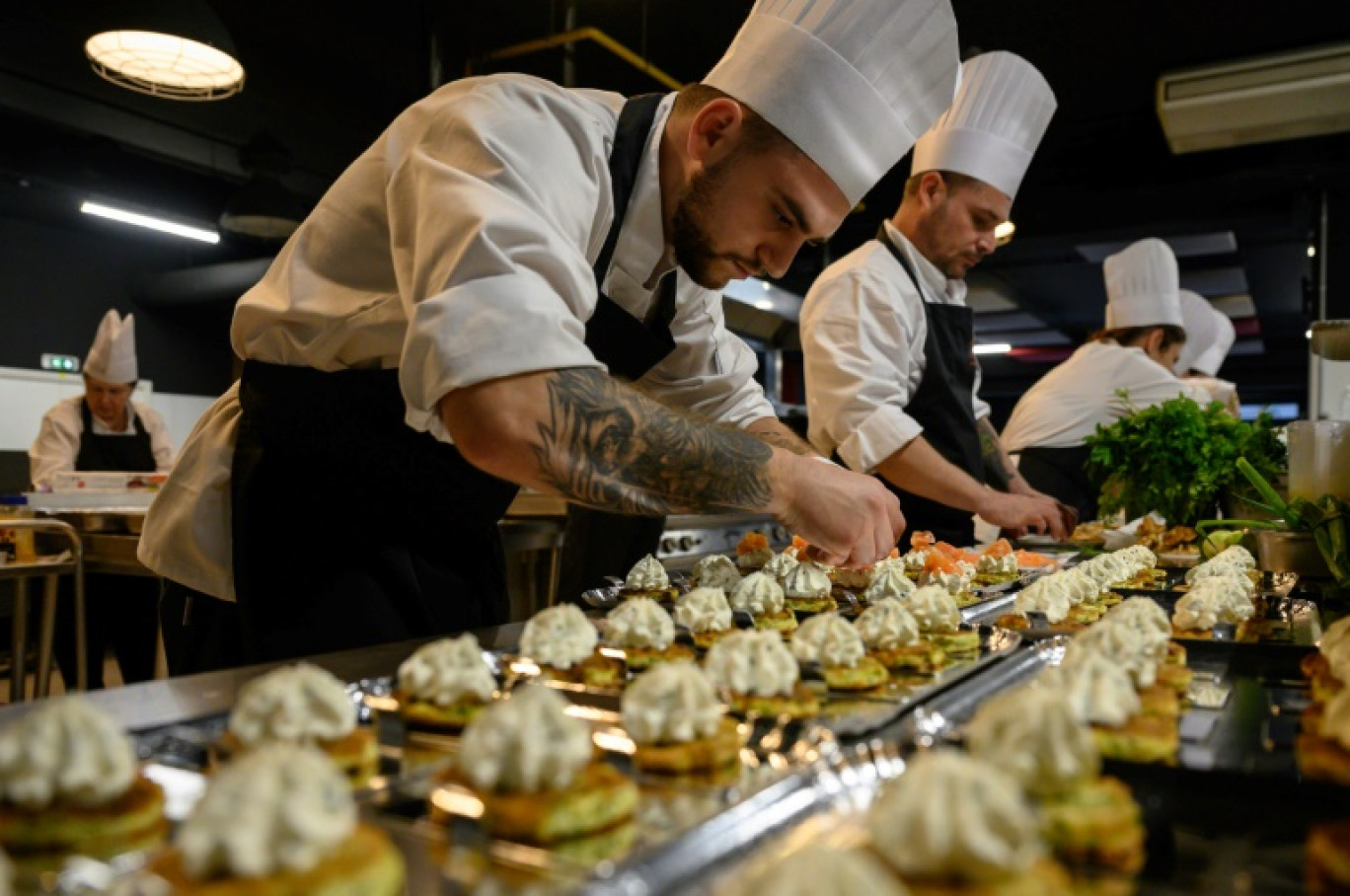 Le chef stagiaire ukrainien Vitalli Aheiiev prépare des plats à l'issue d'un programme de formation en cuisine, le 12 novembre 2024 à Toulouse, dans le sud-ouest de la France © Ed JONES