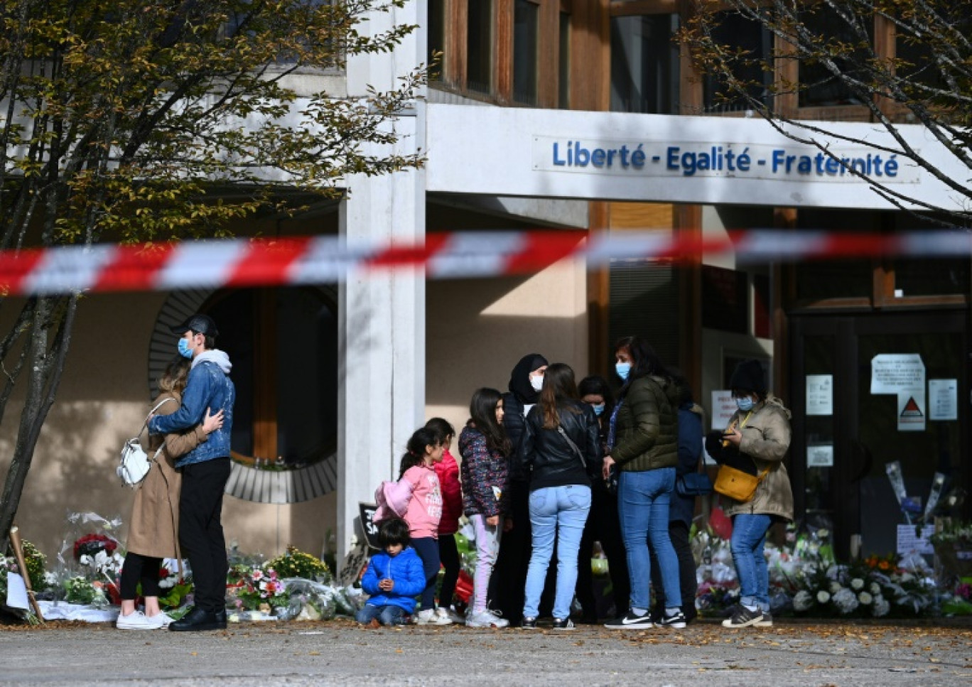 Des personnes sont rassemblées devant le collège du Bois-d'Aulne à Conflans-Sainte-Honorine, dans les Yvelines, le 19 octobre 2020, trois jours après l'assassinat de Samuel Paty © Anne-Christine POUJOULAT