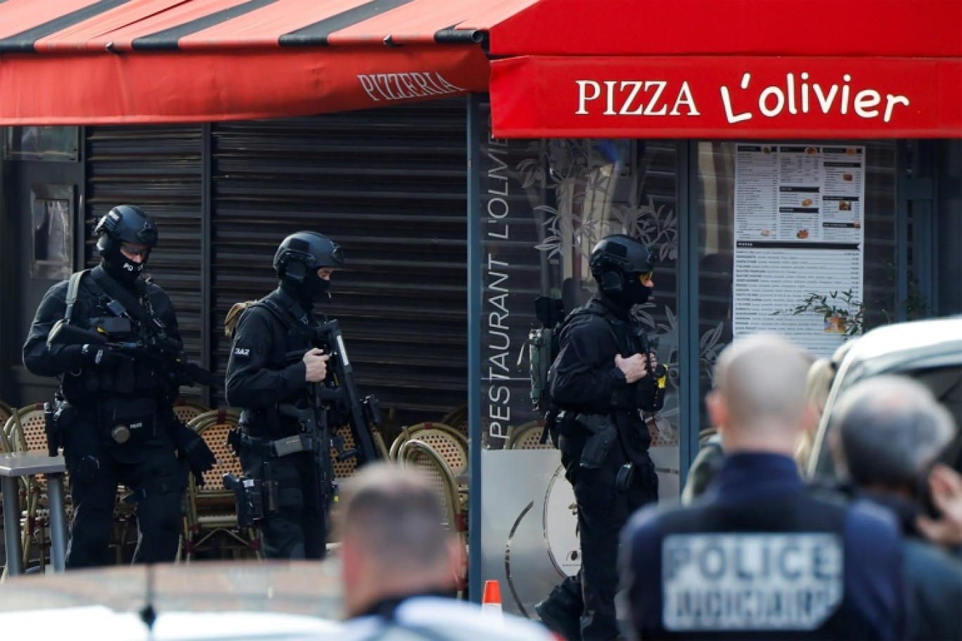 Des policiers devant la pizzeria où un homme s'est retranché à Issy-les-Moulineaux, près de Paris, le 16 novembre 2024 © Ian LANGSDON