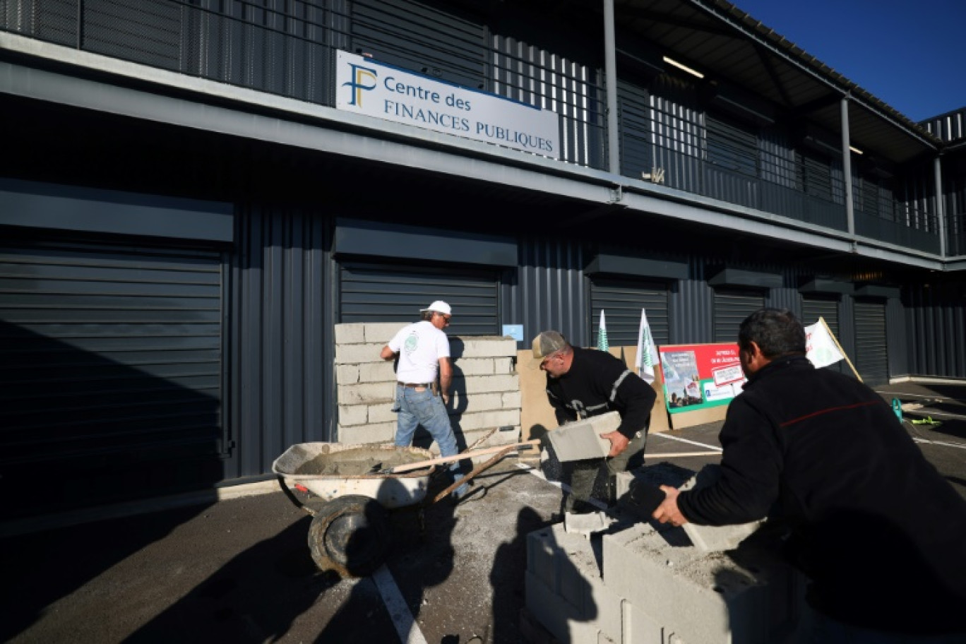 Des agriculteurs ont construit un mur de parpaings devant l'entrée du centre des finances publiques de Châteaurenard le 15 novembre 2024 © Clement MAHOUDEAU