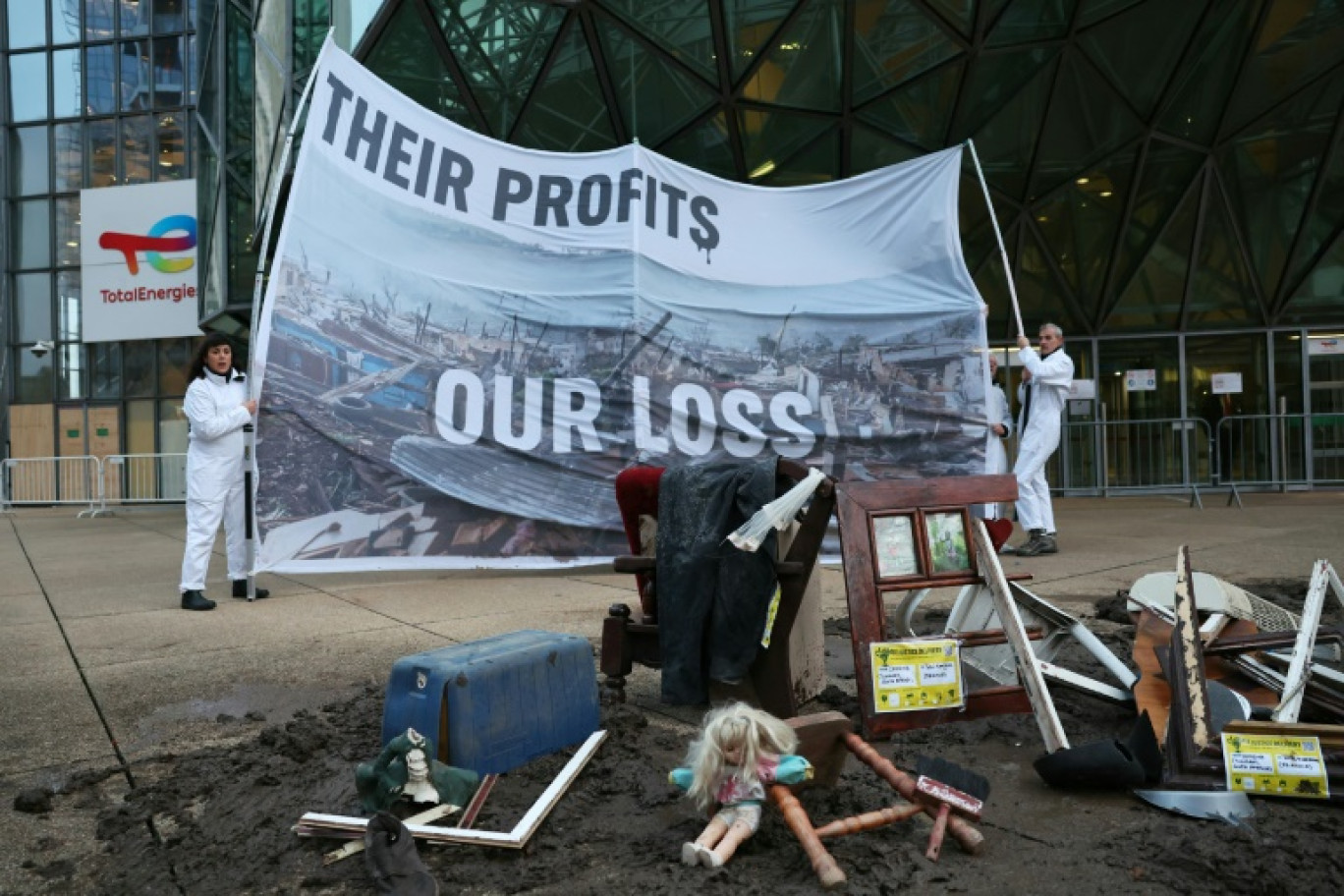 Des militants de Greenpeace ont déposé lundi devant la siège de TotalEnergies à La Défense des objets provenant d'une tornade en Afrique du Sud et déployé une banderole "their profits our loss" ("leurs profits, nos pertes") pour demander la taxation des géants pétroliers et gaziers au profit du fonds pour les désastres climatiques. Photo prise le 18 novembre © ALAIN JOCARD