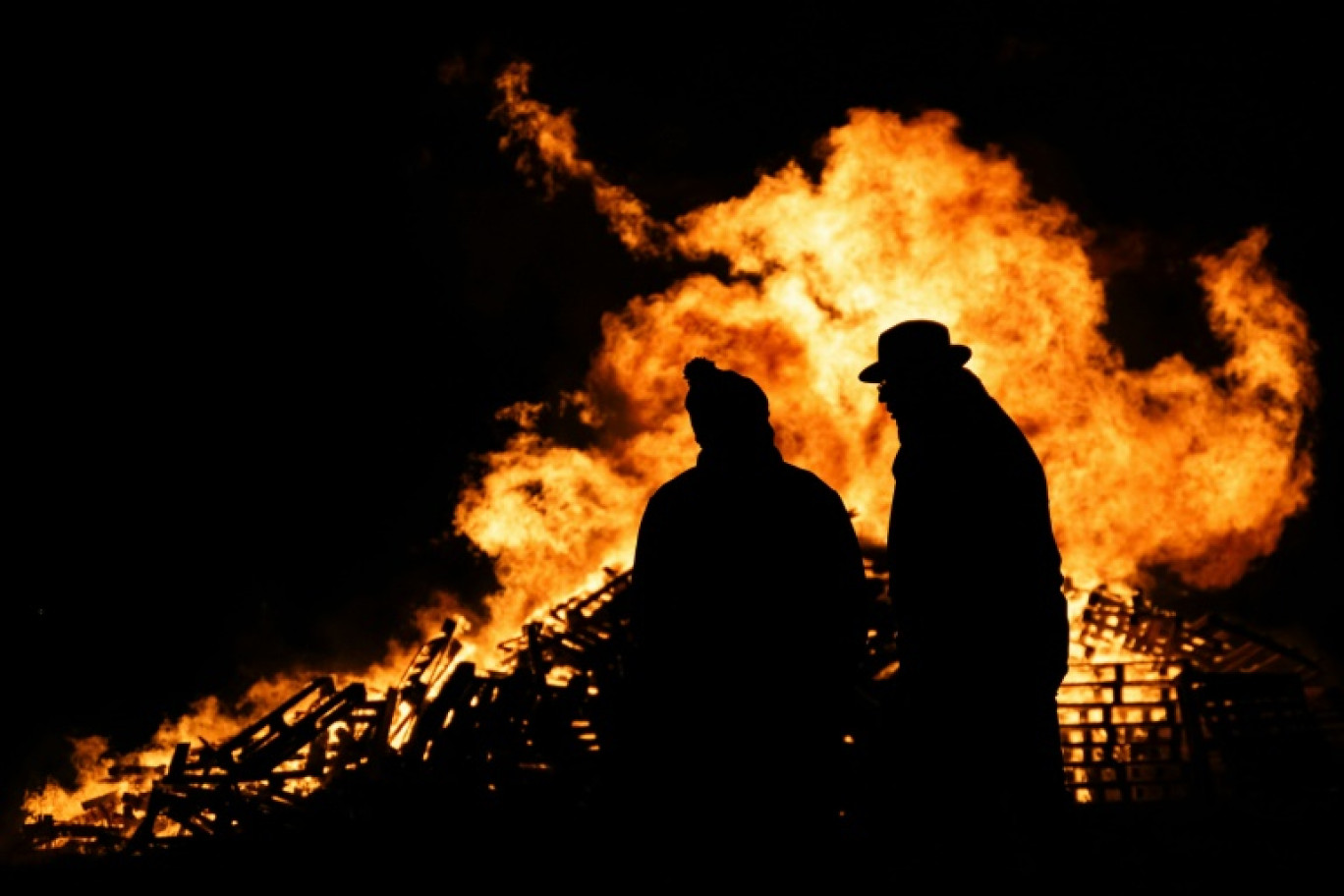 Deux agriculteurs devant un feu allumé lors d'un rassemblement contre la signature d'un accord de libre-échange entre l'Union européenne et des pays du Mercosur, à Dijon le 18 novembre 2024 © ARNAUD FINISTRE