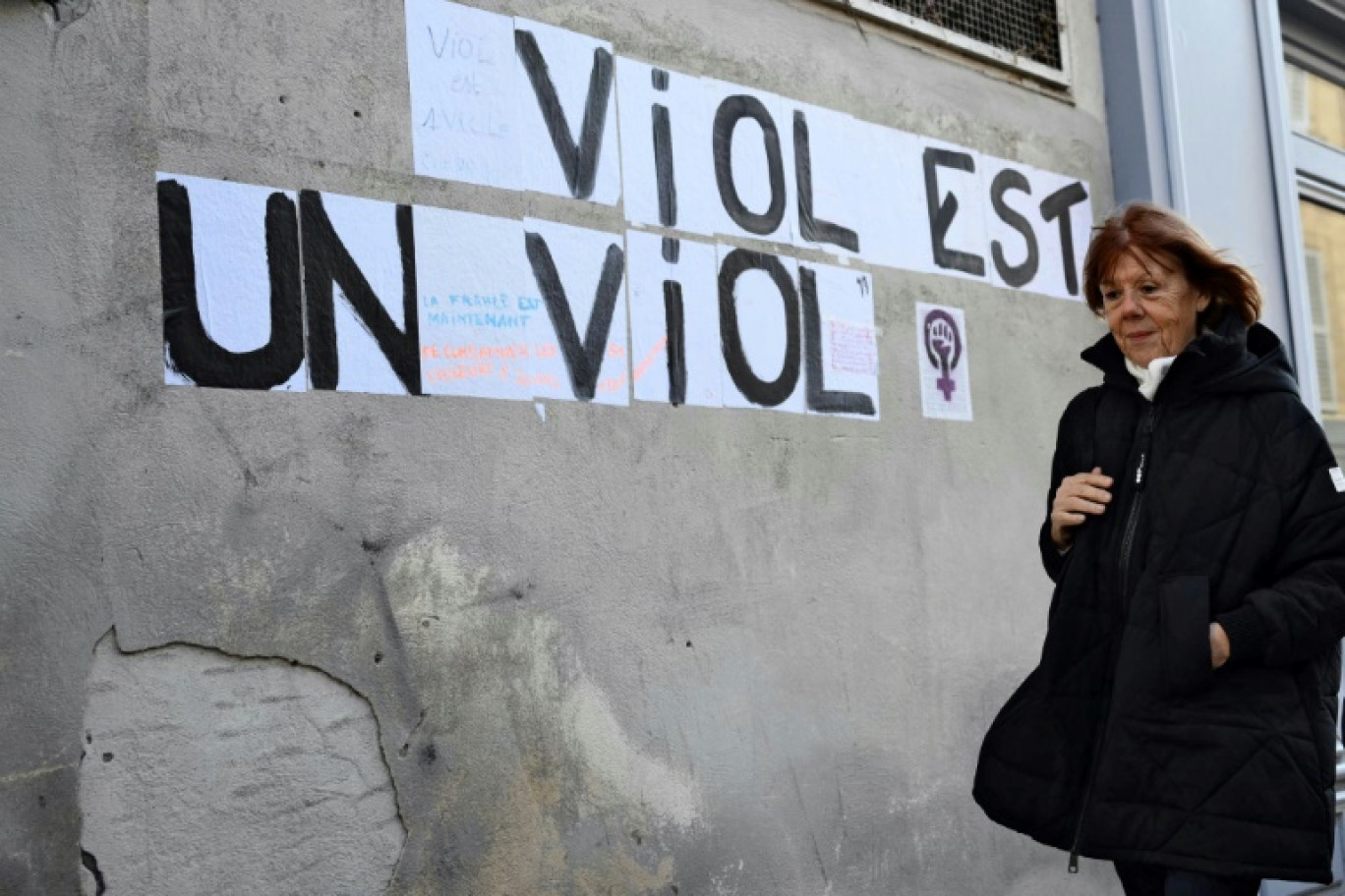 Gisèle Pelicot marche devant un mur où un collage a été apposé, à l'extérieur du tribunal d'Avignon, le 14 novembre 2024 © Christophe SIMON