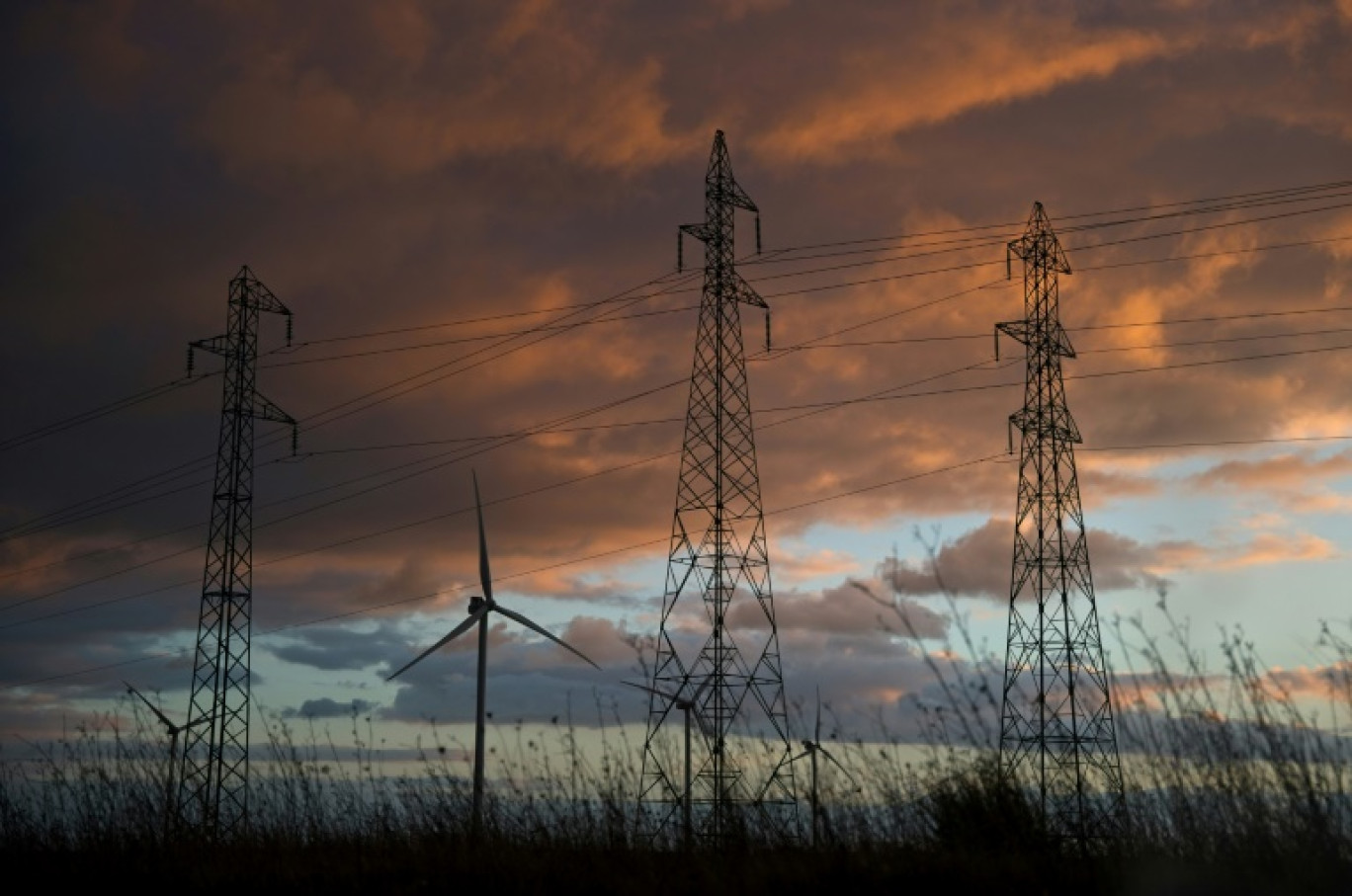 Des turbines éoliennes et des pylônes électriques près d'Allonnes, dans le centre de la France, le 31 janvier 2022 © GUILLAUME SOUVANT