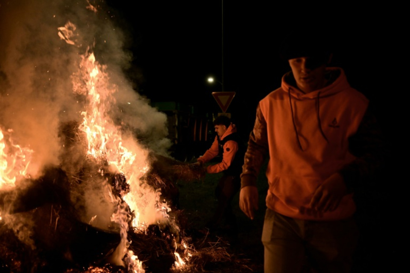 Des agriculteurs français et des membres du syndicat agricole Coordination Rurale (CR) se rassemblent autour d'un feu pendant le blocage du port de Bordeaux, à Bassens, le 20 novembre 2024 © Philippe LOPEZ