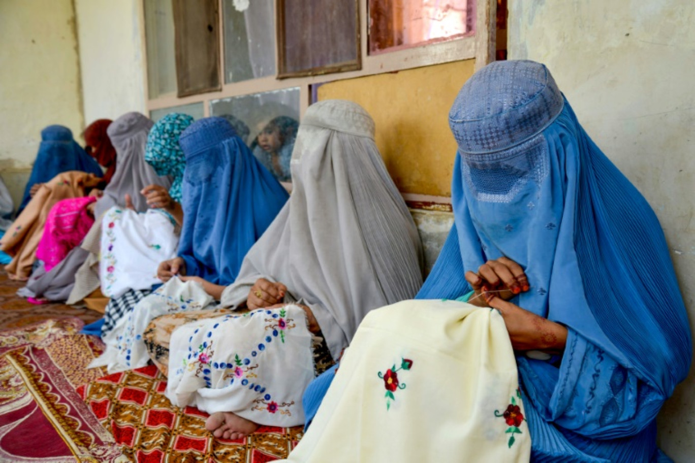 Des femmes afghanes en burqa brodent des mouchoirs lors d'un atelier à Kandahar le 4 septembre 2024 © Sanaullah SEIAM