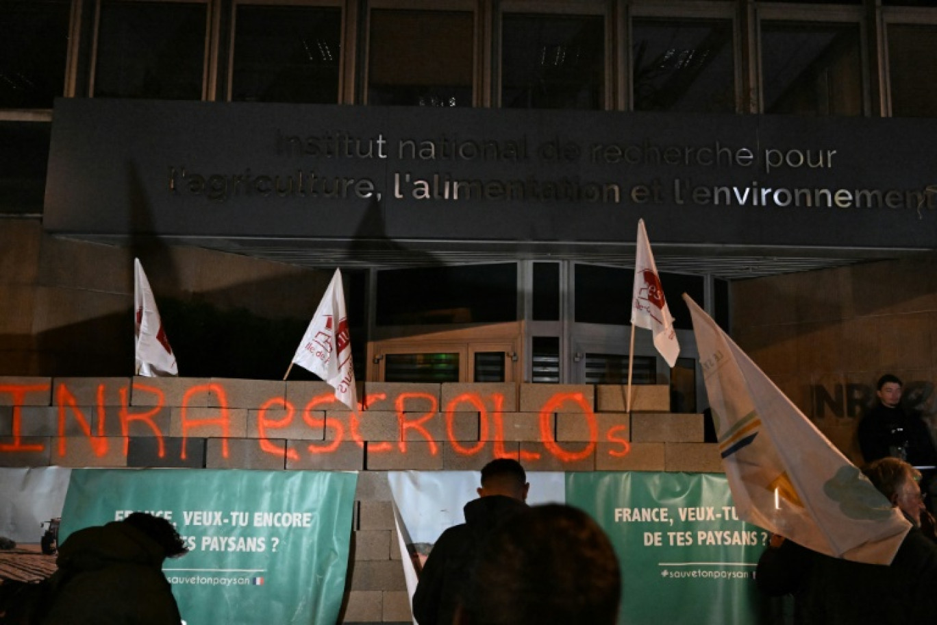 Des agriculteurs devant l'Inrae après avoir érigé un mur en parpaings devant l'institut, le 28 novembre 2024 à Paris © Gregoire CAMPIONE