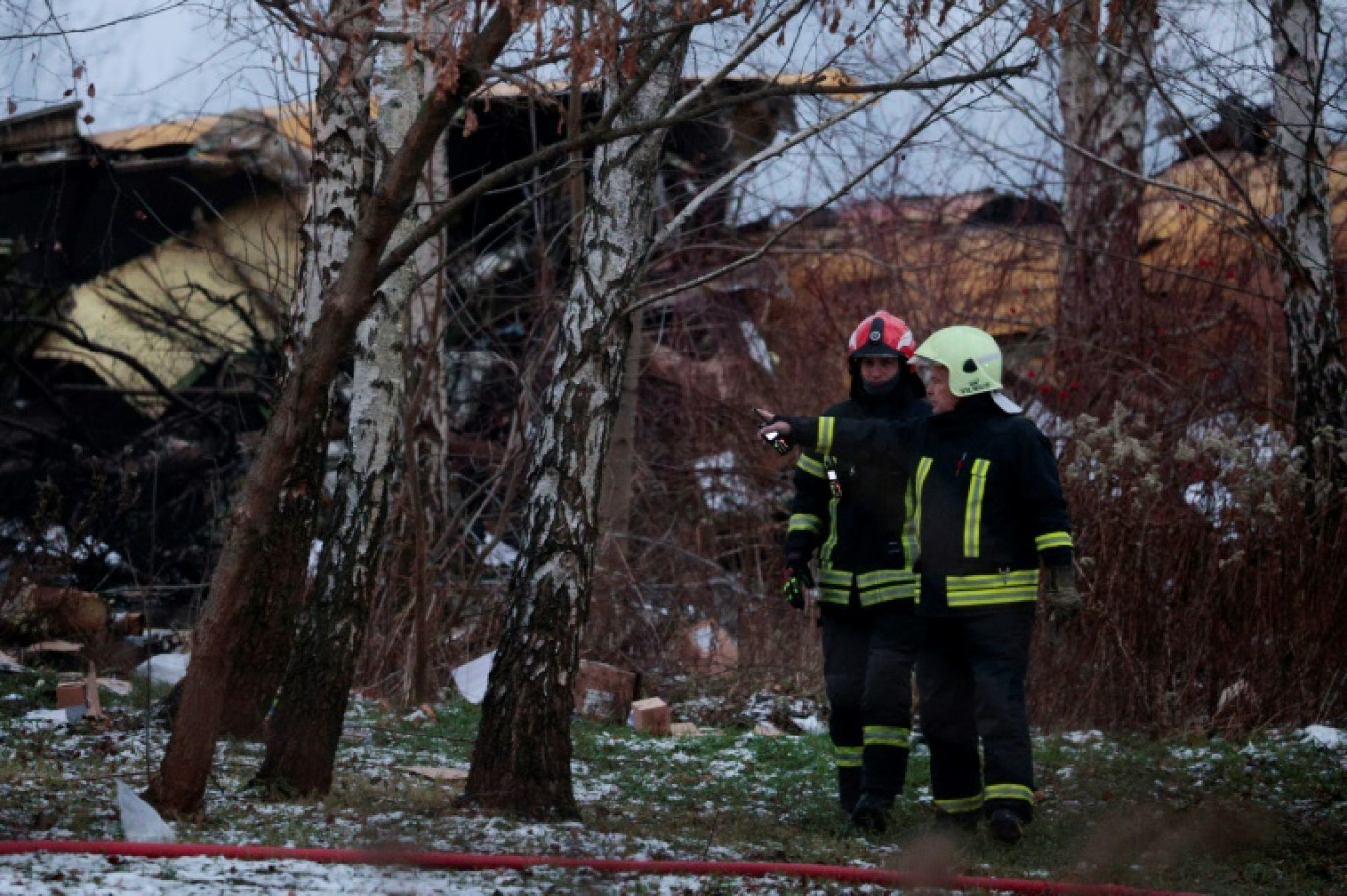 Des pompiers lituaniens travaillent à côté de l'épave d'un avion cargo qui s'est écrasé près de l'aéroport international de Vilnius, le 25 novembre 2024 © Petras MALUKAS