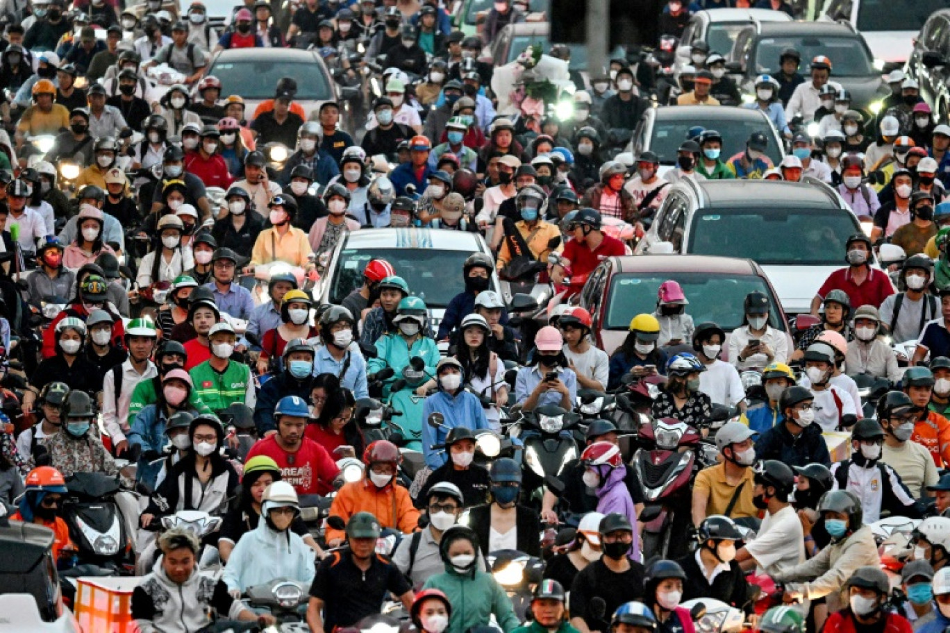 Circulation dense de scooters électriques et d'automobiles dans une rue de Hanoï, le 11 novembre 2024 au Vietnam © Nhac NGUYEN