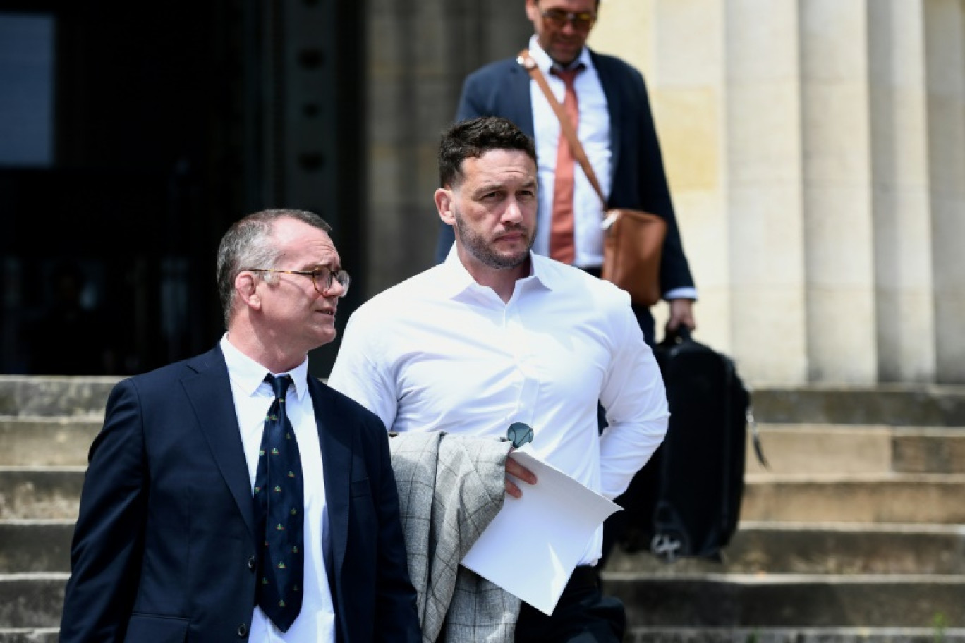 Le rugbyman néo-zélandais Rory Grice (c) quitte le tribunal après une audience au palais de justice de Bordeaux, le 17 juin 2024 en Gironde © Christophe ARCHAMBAULT