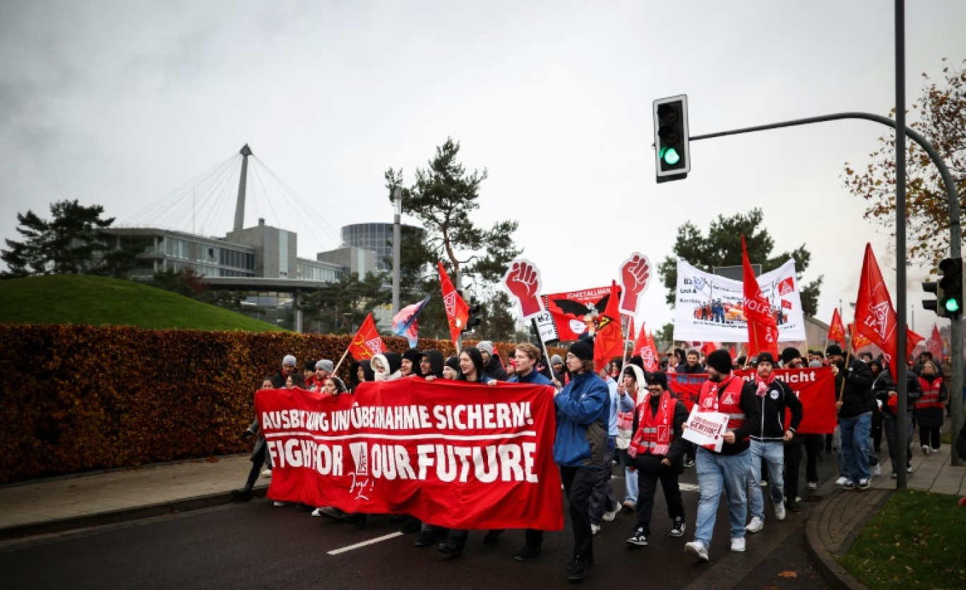 Des employés du constructeur automobile allemand Volkswagen déploient une banderole portant l'inscription "Fight for our Future" lors d'une manifestation à l'usine Volkswagen de Wolfsburg, dans le nord de l'Allemagne, le 21 novembre 2024 © Ronny HARTMANN