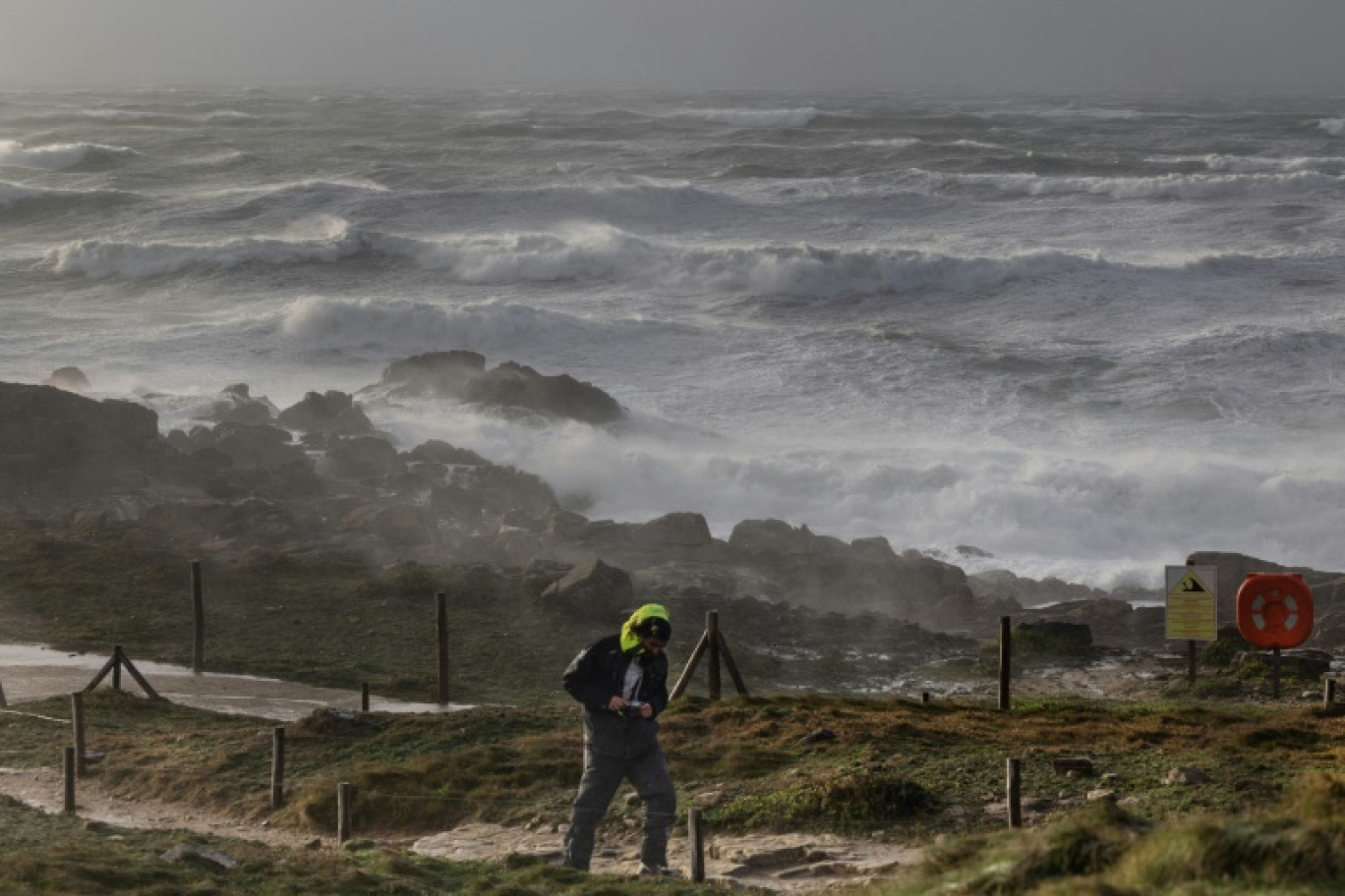 Un homme sur un sentier à La pointe de la Torche alors que la tempête Darragh et ses vents violents balaient la côte à Plomeur, dans le Finistère, le 7 décembre 2024 © FRED TANNEAU